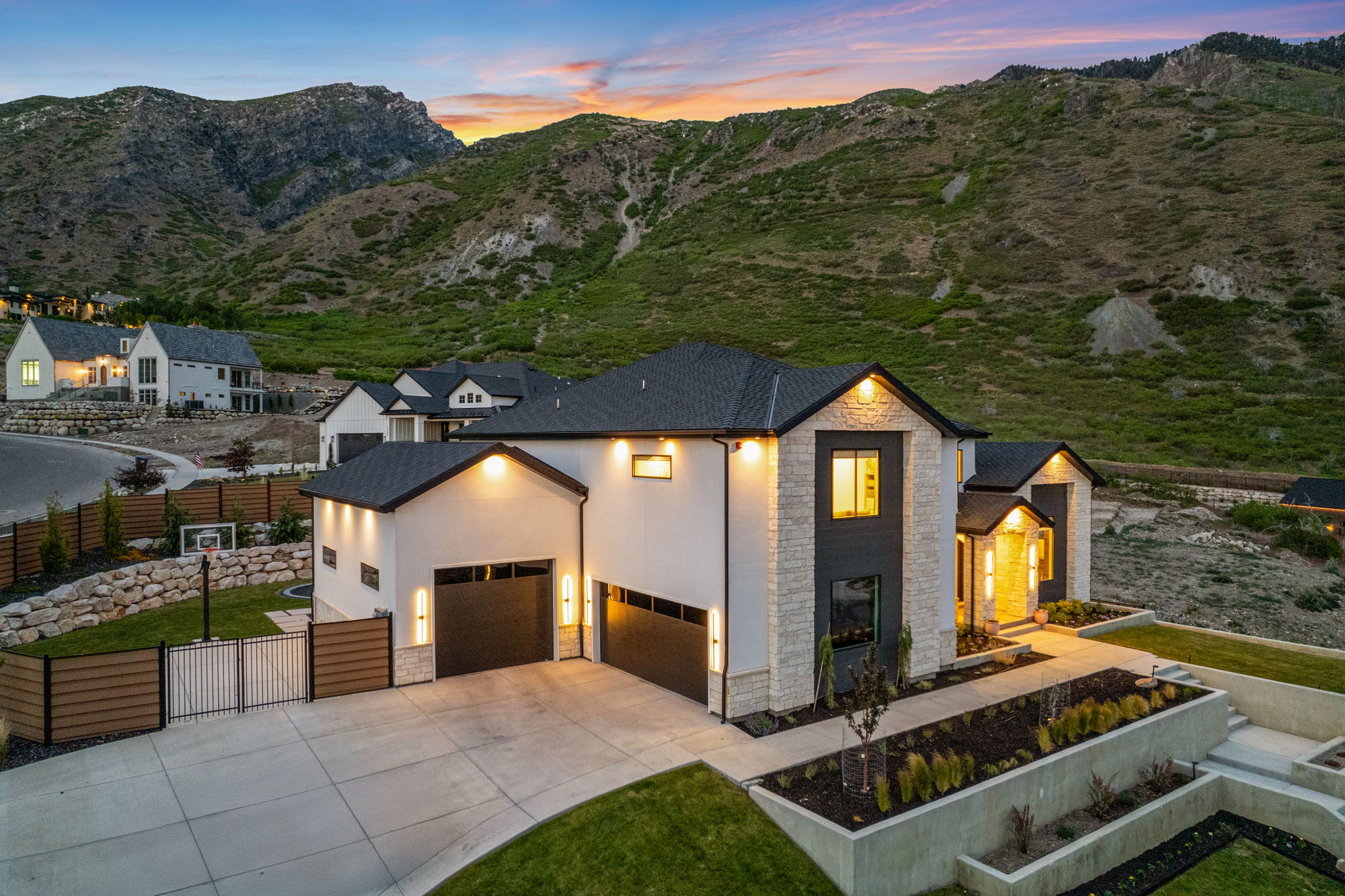 Modern architectural residence featuring a white stucco and stone facade with black trim