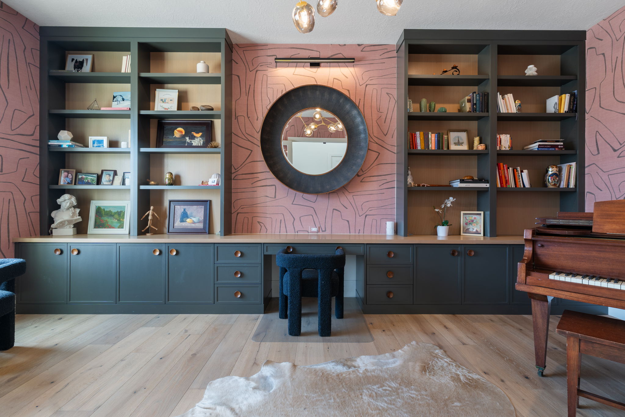 Built-in shelving and cabinetry featuring a light wood-finish countertop, dark gray shaker-style doors, and brass hardware
