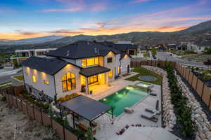 Modern home with stone and stucco facade, featuring an integrated swimming pool and hot tub