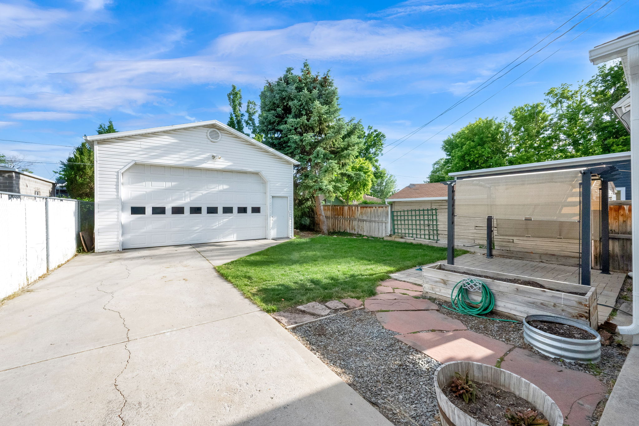 Detached two-car garage with a side entry door and concrete driveway