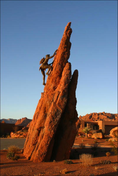 Dramatic rock formation with a bronze climber sculpture