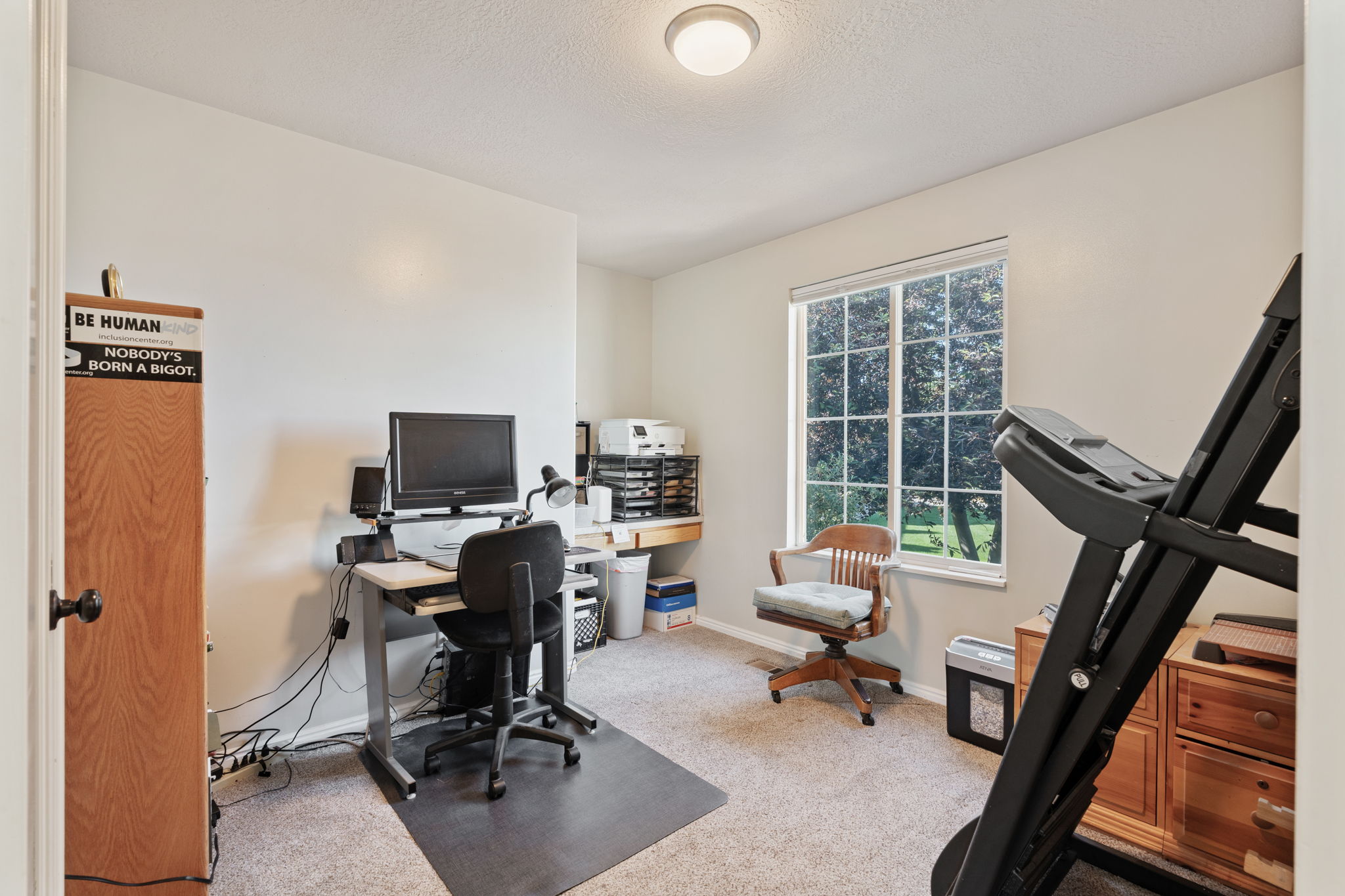 Carpeted room featuring a large window, a light-colored ceiling, and white wall finishes