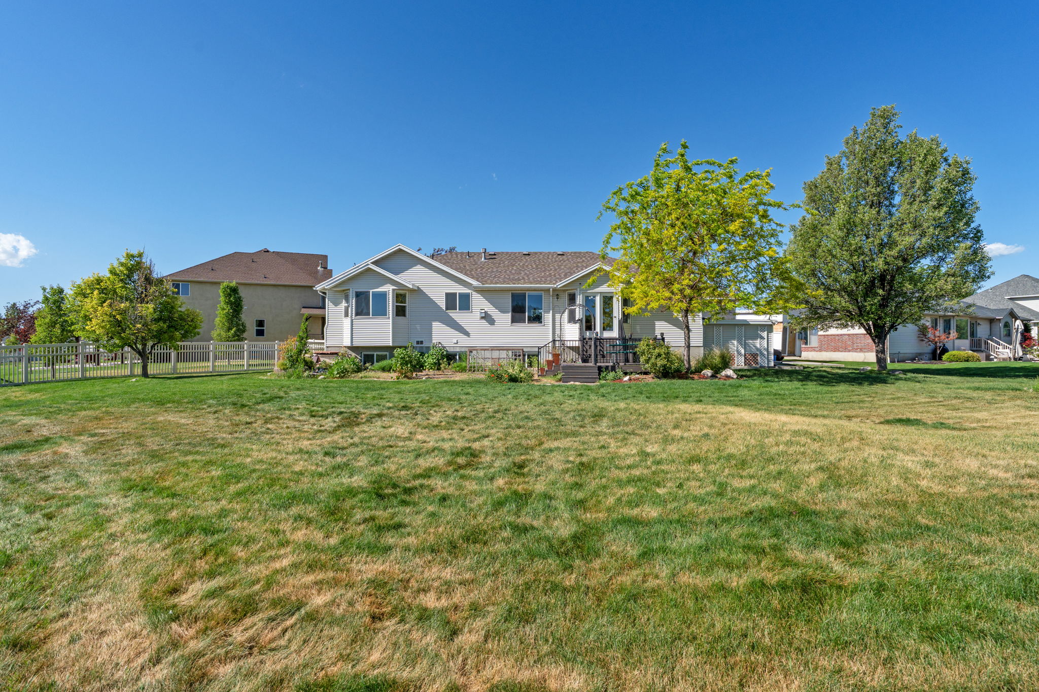 Expansive yard featuring a manicured lawn and mature trees