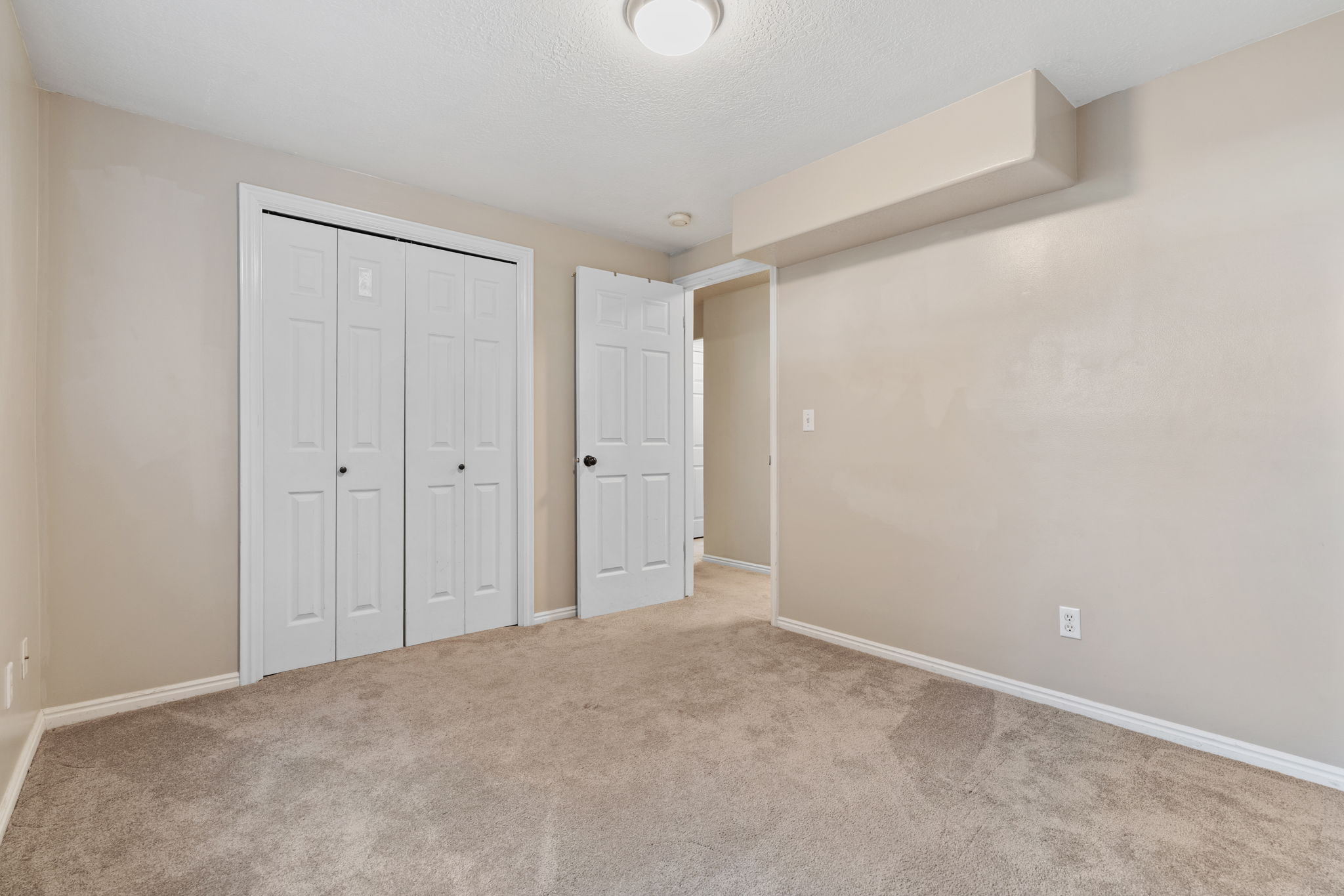 Neutral-toned wall paint and plush carpet flooring throughout
