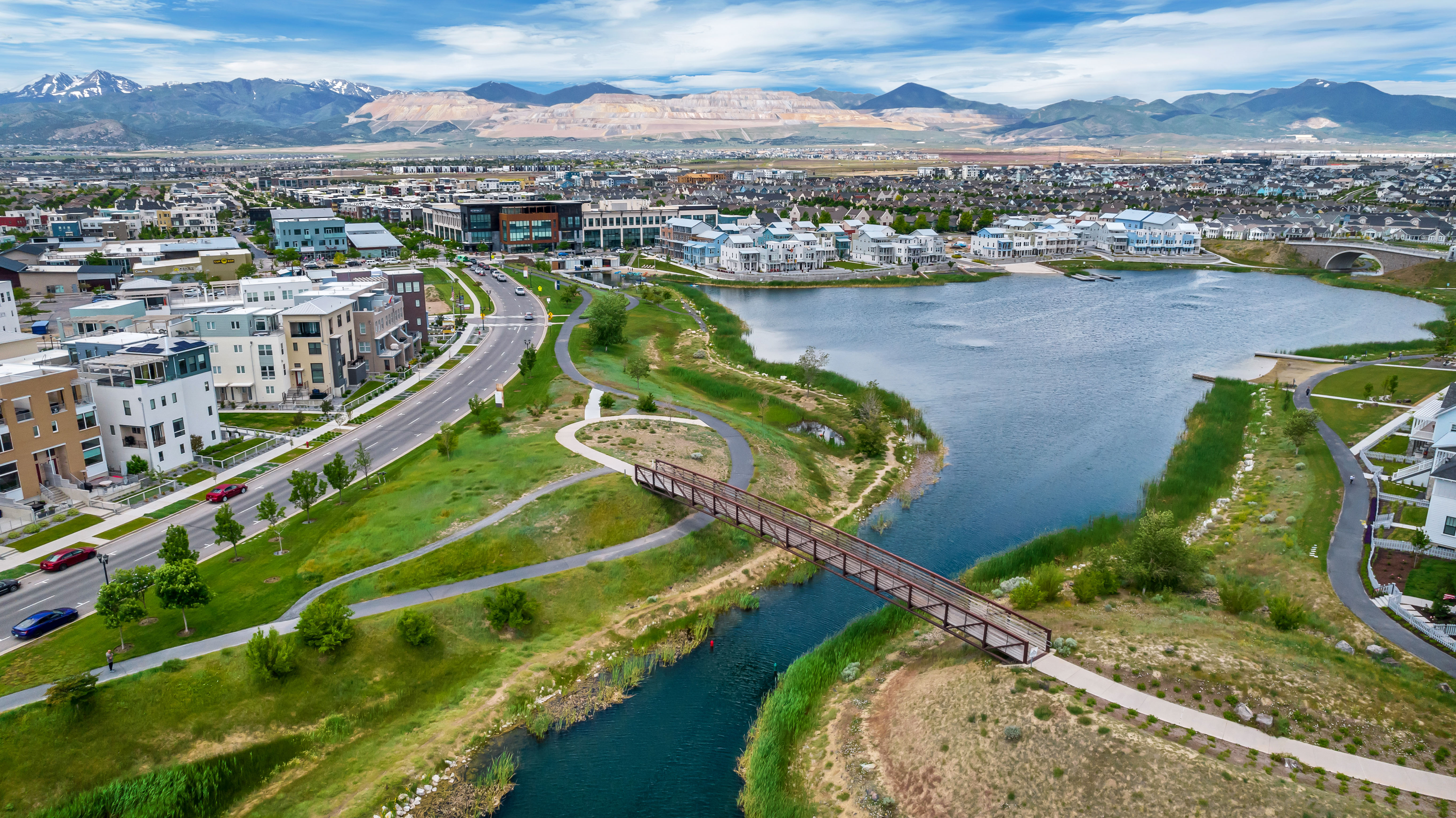 Aerial perspective showcasing a community with varied architectural styles, a prominent waterway, and expansive green spaces