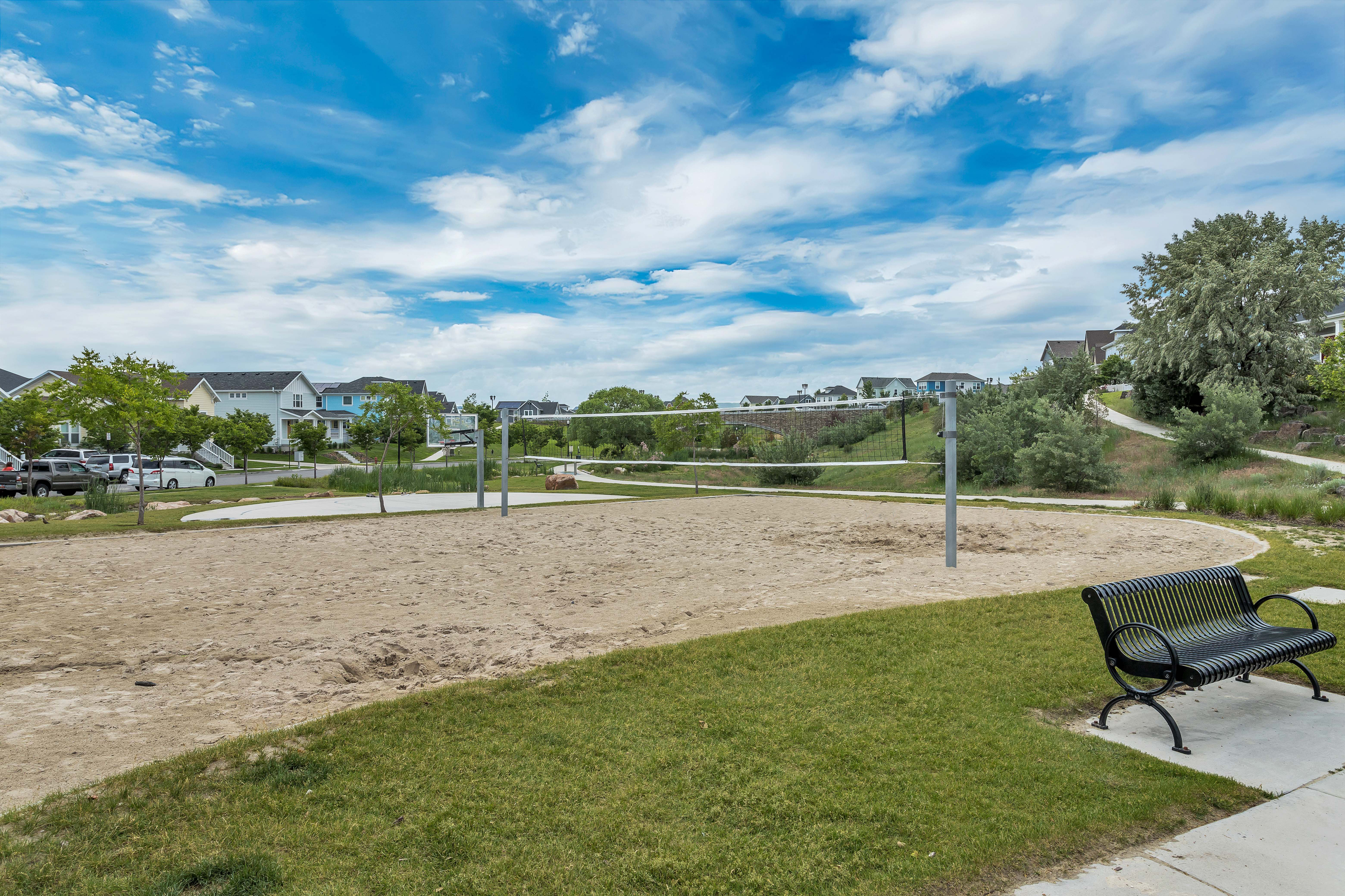 Community volleyball court featuring sand playing surface and permanent netting