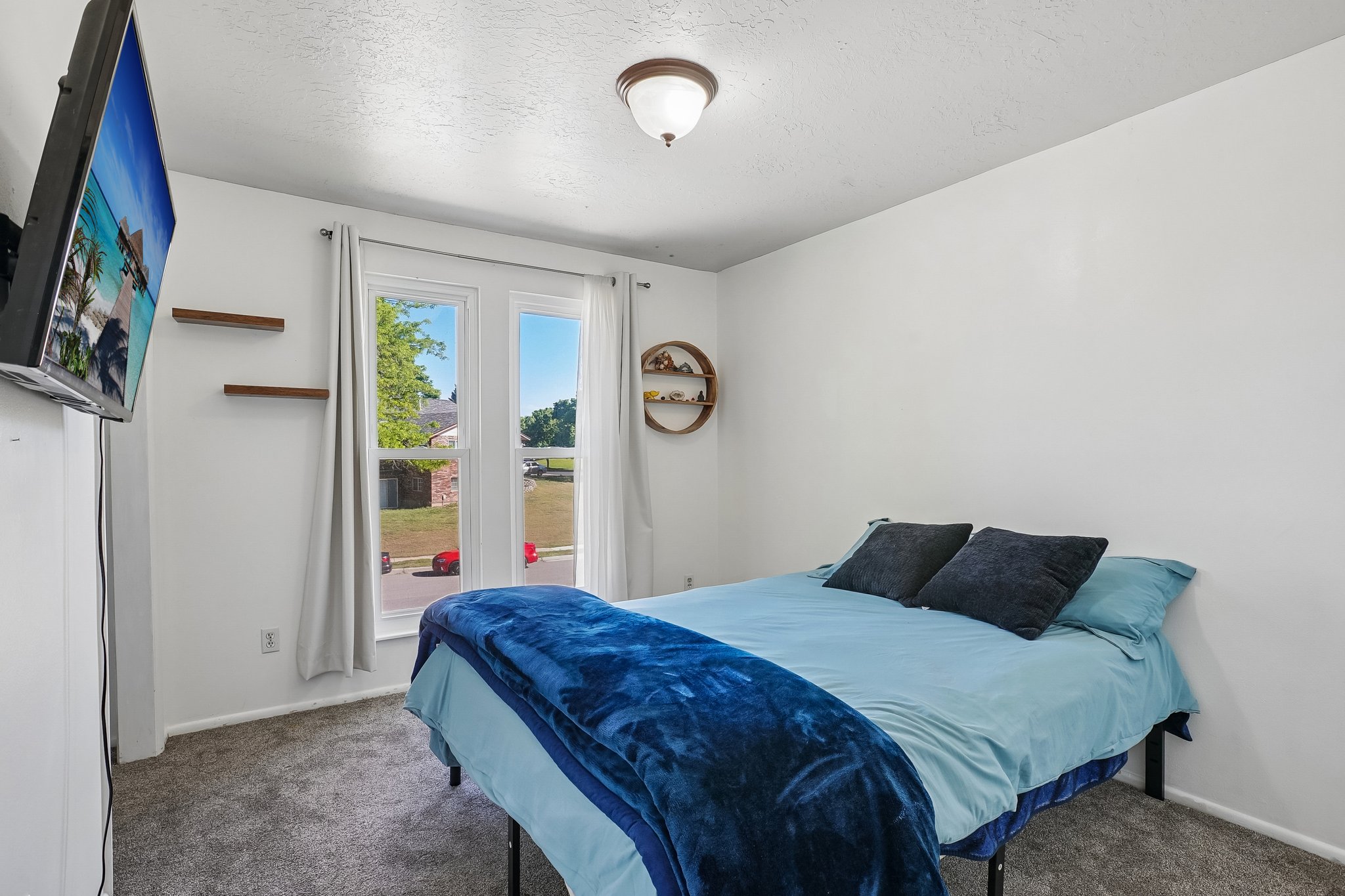 White walls, recessed window with a double pane, wall-mounted floating shelves, and a ceiling light fixture