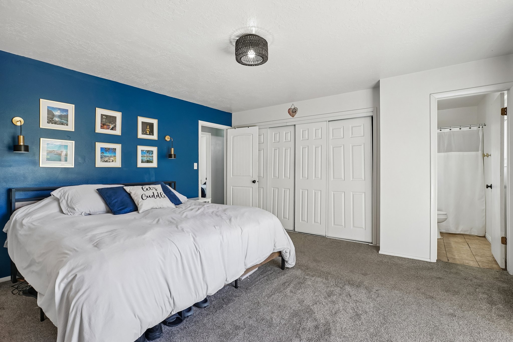 Spacious room featuring a deep blue accent wall, two sets of white bi-fold closet doors, and recessed lighting