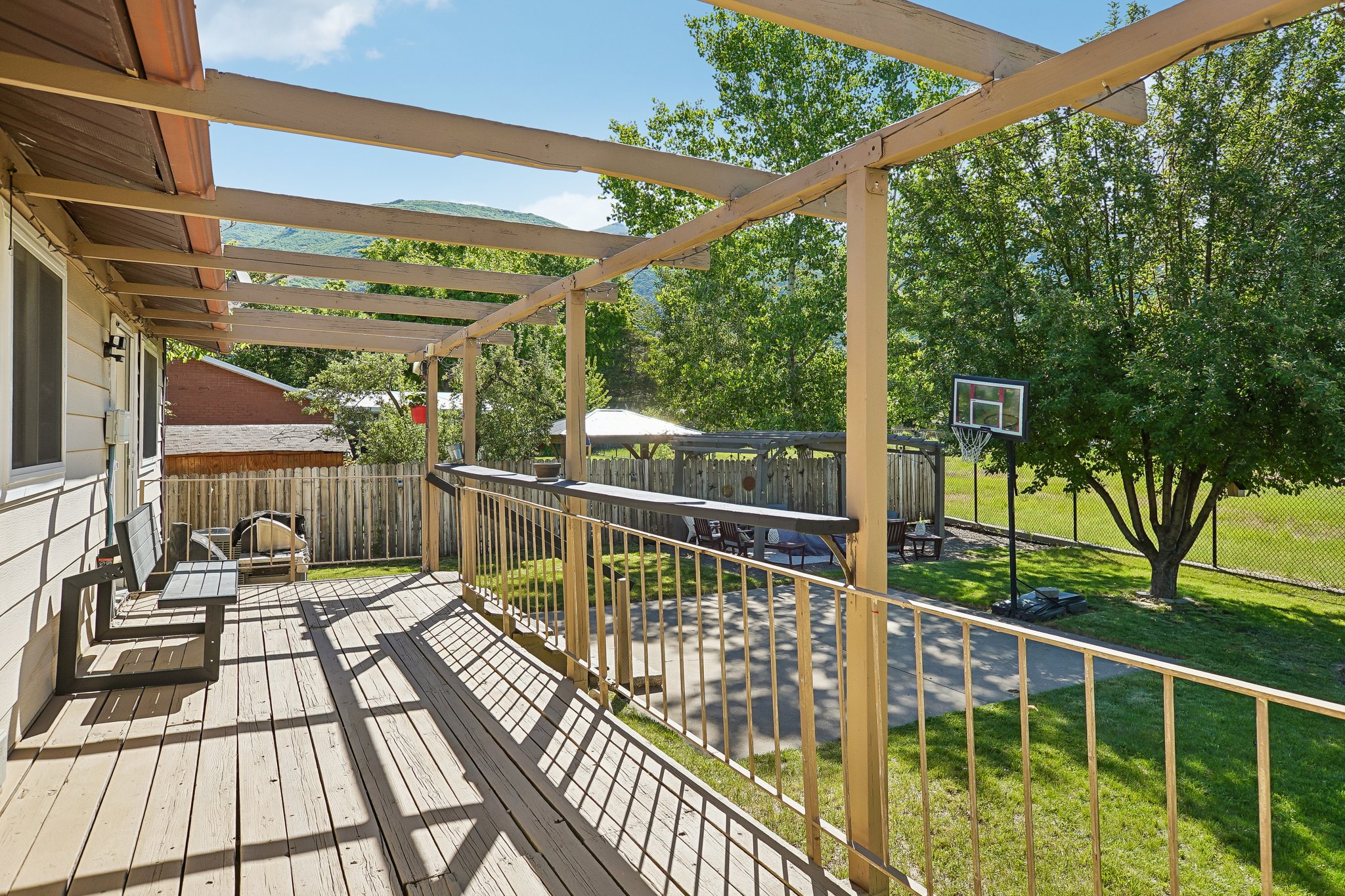 Expansive outdoor deck featuring a wooden pergola and perimeter railing