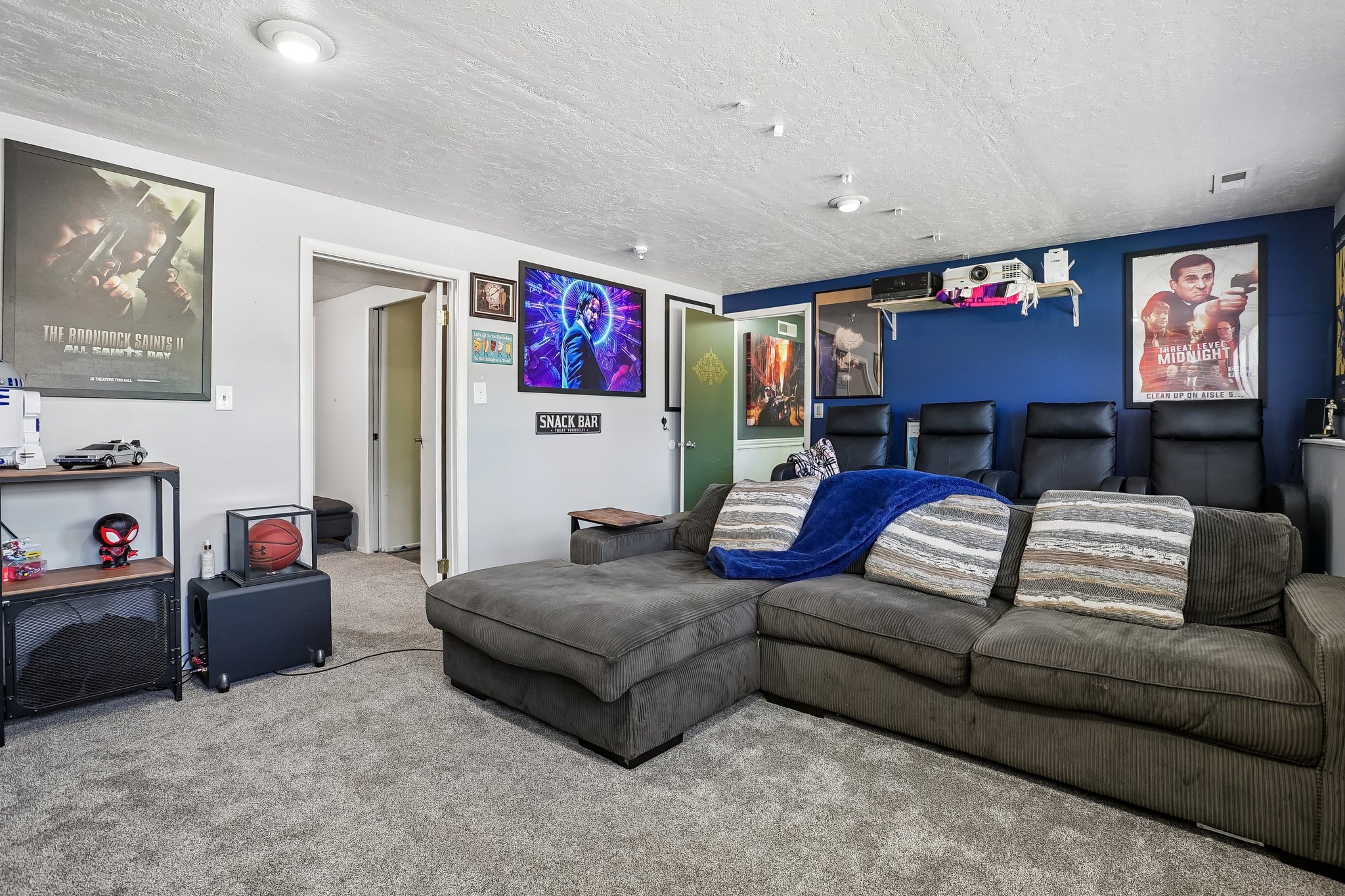Carpeted entertainment area featuring recessed lighting and a dedicated media wall with projector