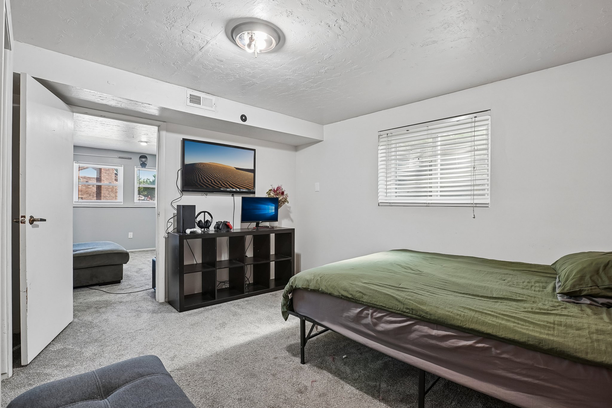 Carpeted interior space with a single window featuring horizontal blinds and white trim