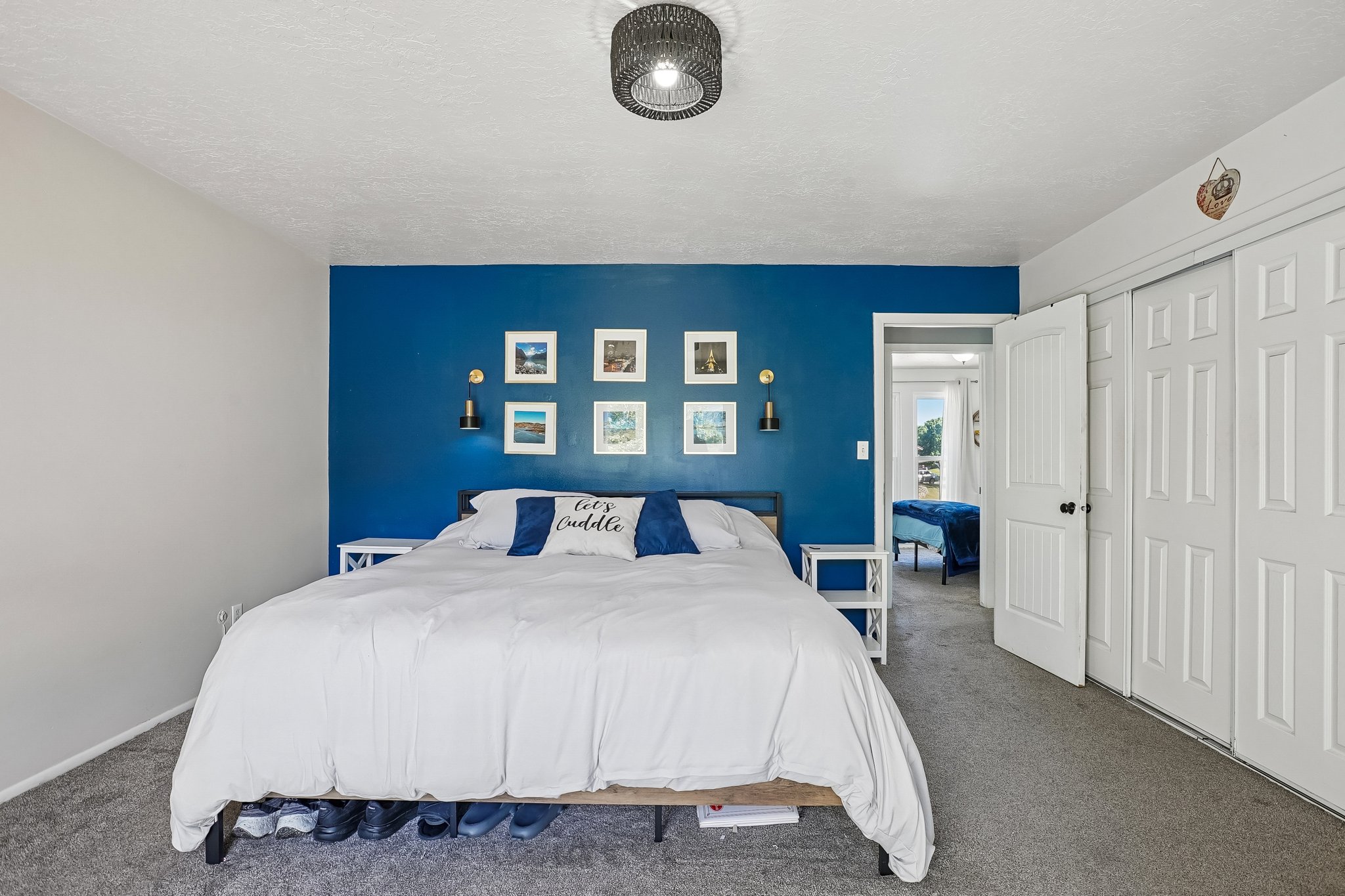 Bedroom featuring an accent wall, wall-mounted sconces, and a ceiling-mounted light fixture