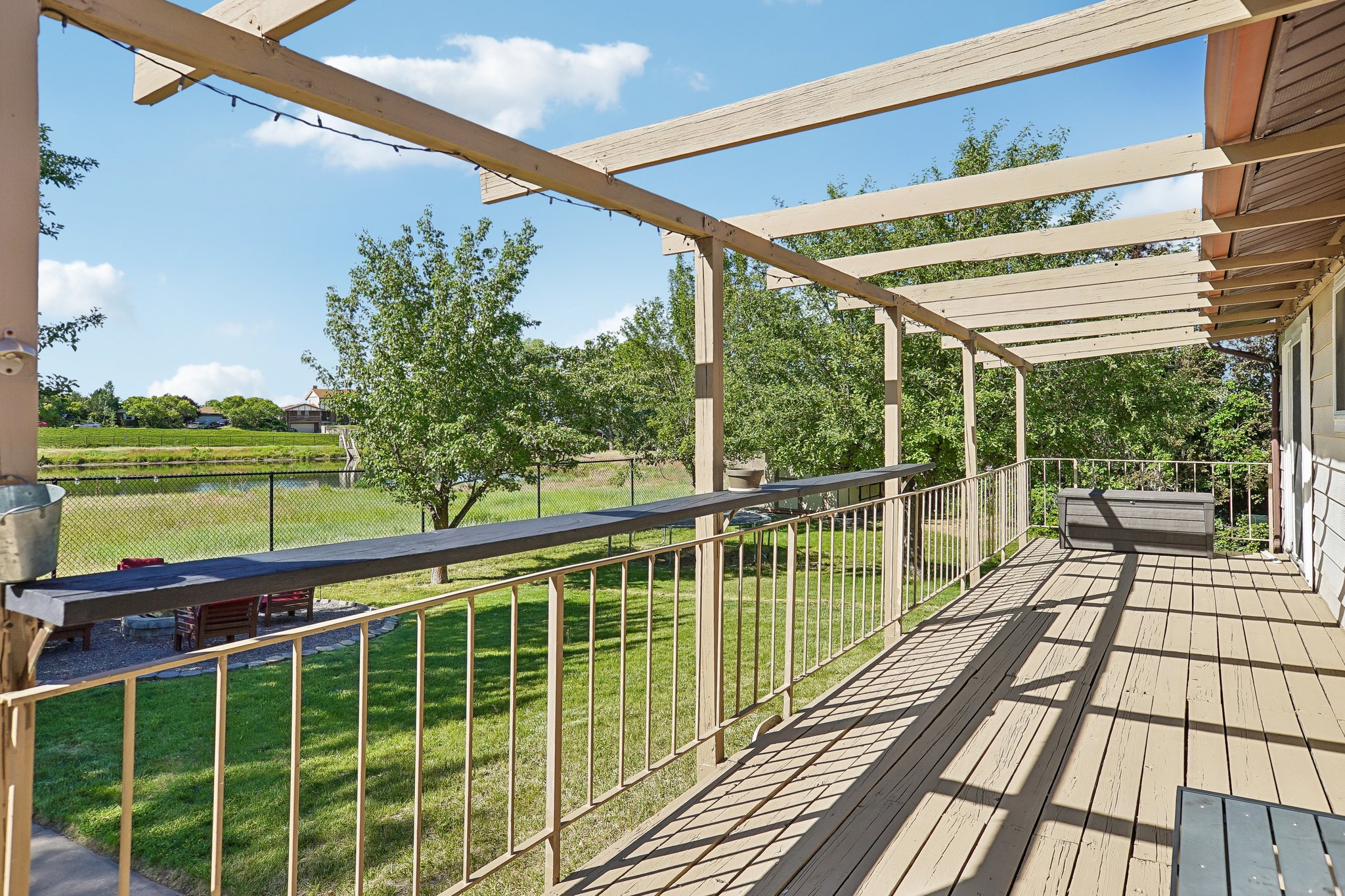 Expansive outdoor deck featuring wood flooring and an overhead pergola
