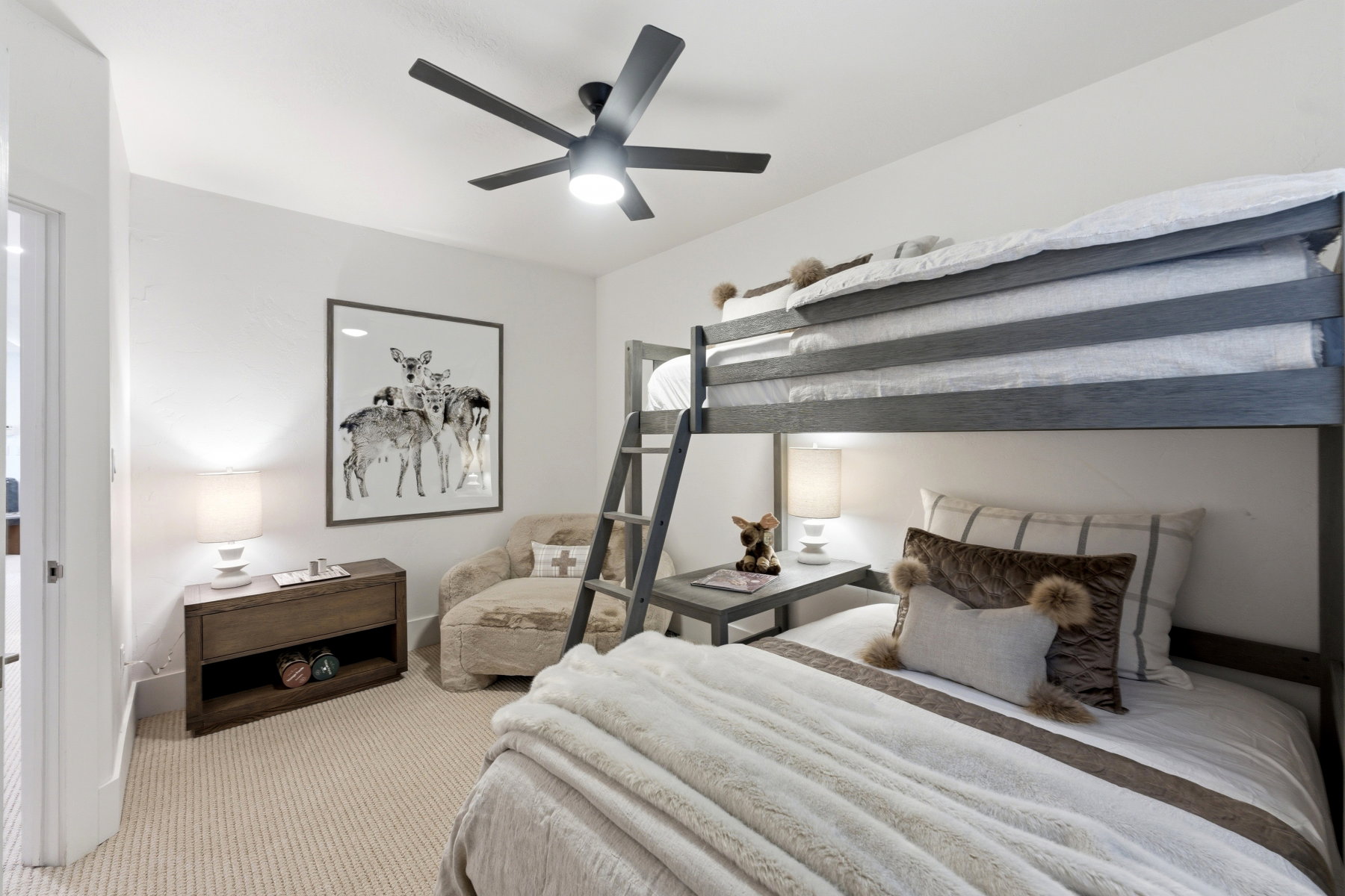 White walls with light-toned carpet flooring, featuring a dark gray bunk bed with an integrated ladder