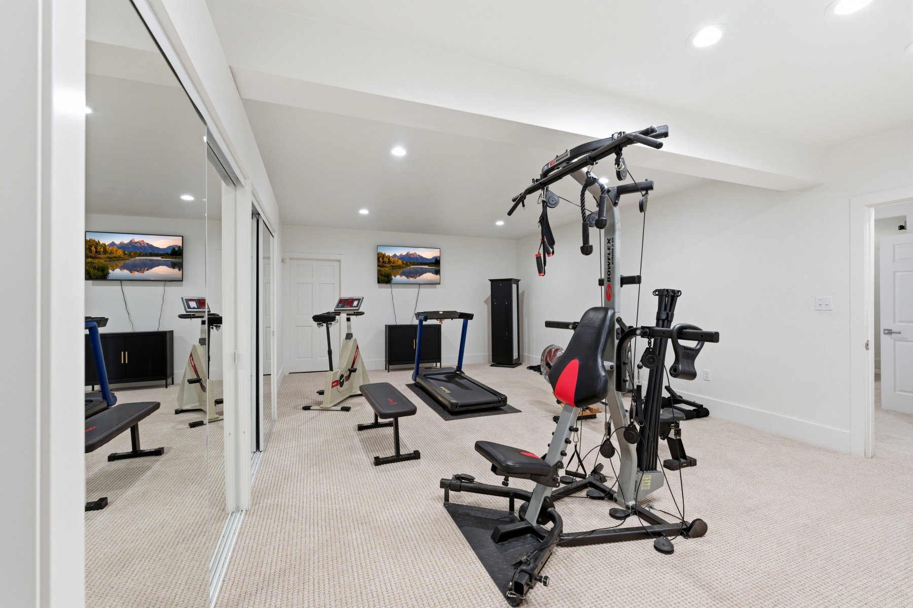 Spacious room featuring neutral carpet flooring, recessed lighting, and mirrored sliding closet doors