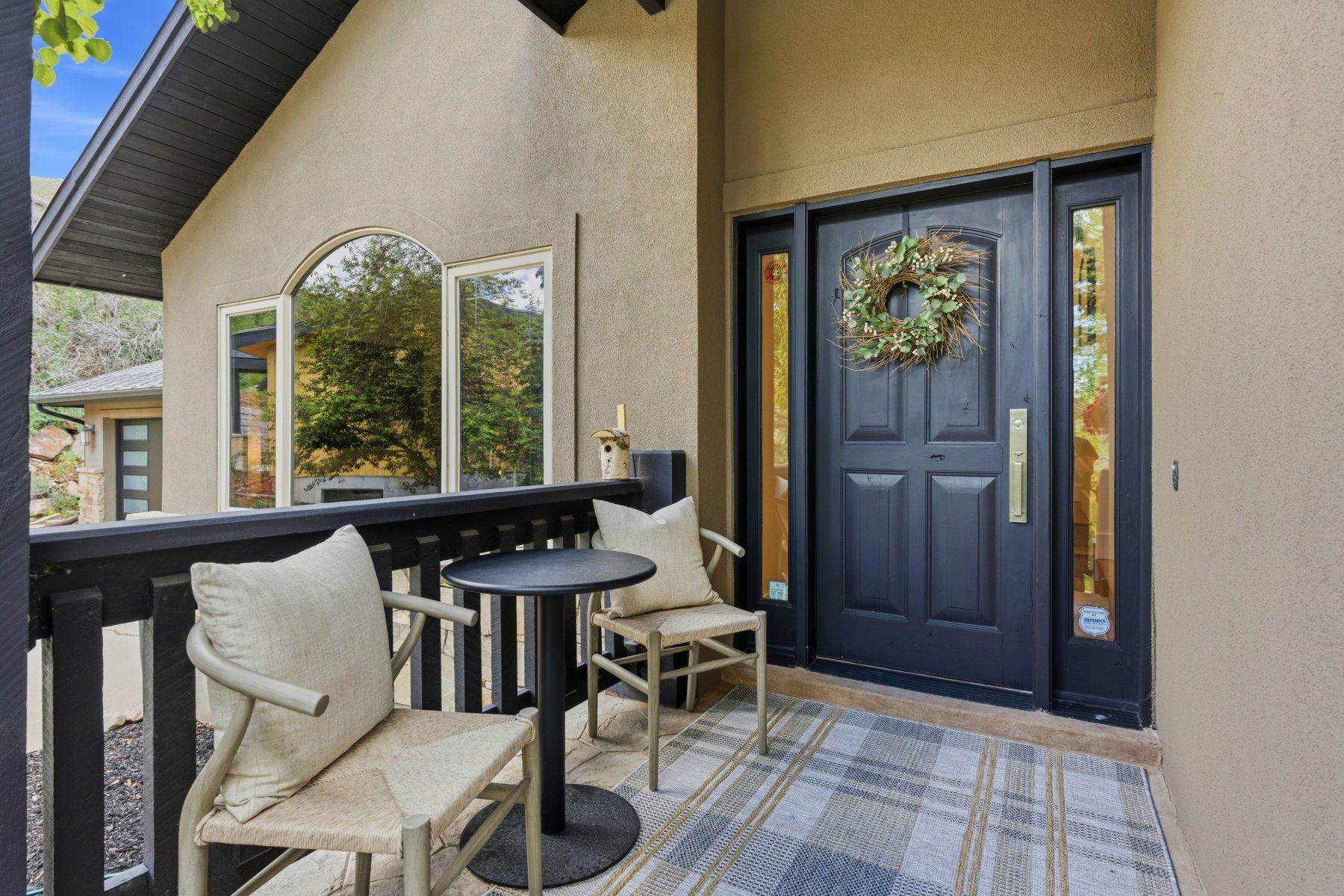 Front entry featuring a dark paneled door with sidelight windows and a brass handle