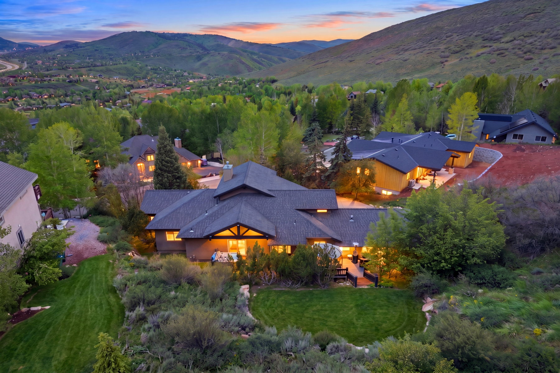 Expansive property with a multi-level structure featuring a dark shingled roof and exposed wood beams