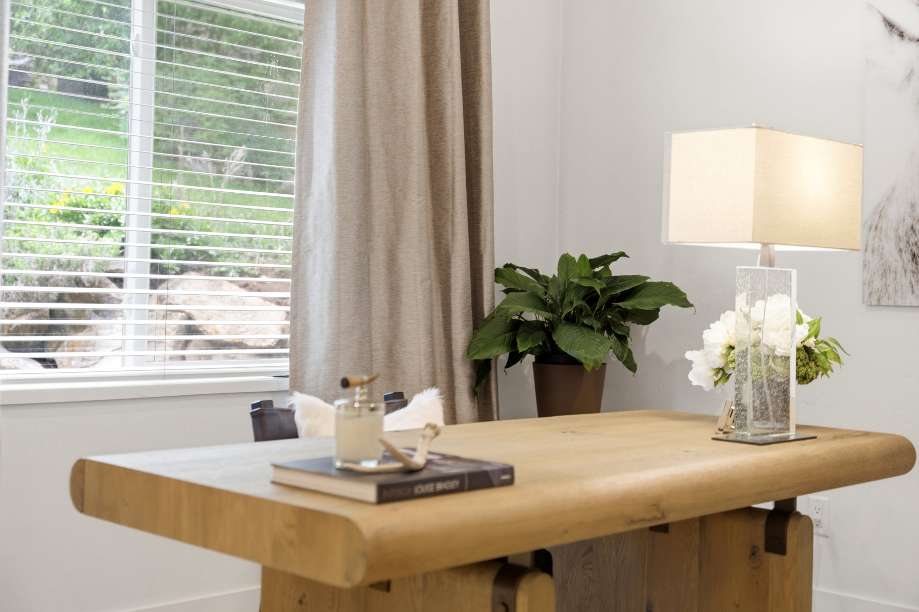 Recessed window featuring horizontal blinds and a floor-length curtain