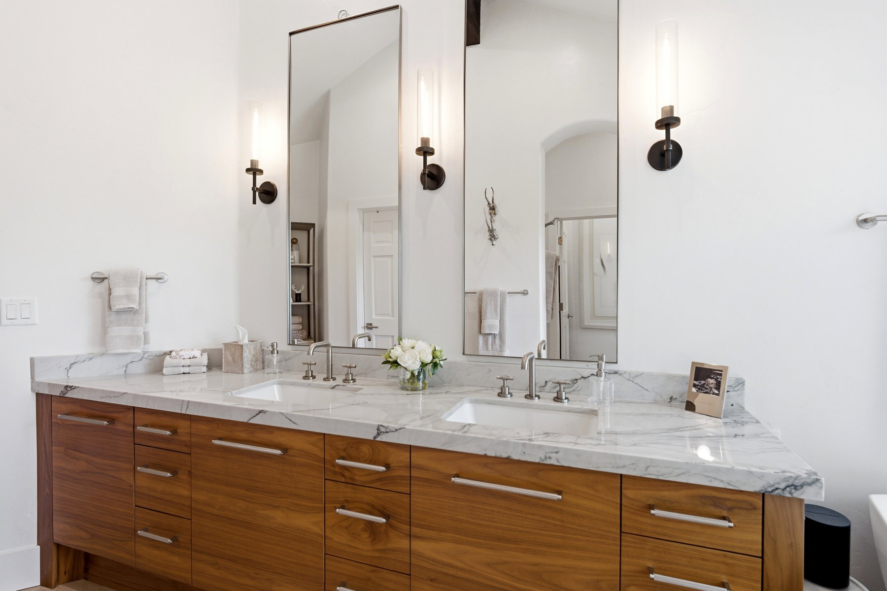 Double vanity with wood-finish cabinetry and a stone countertop