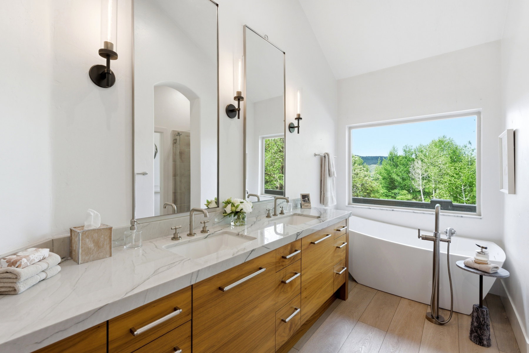 Bathroom featuring a double vanity with stone countertop, wood-finish cabinetry, and brushed nickel hardware