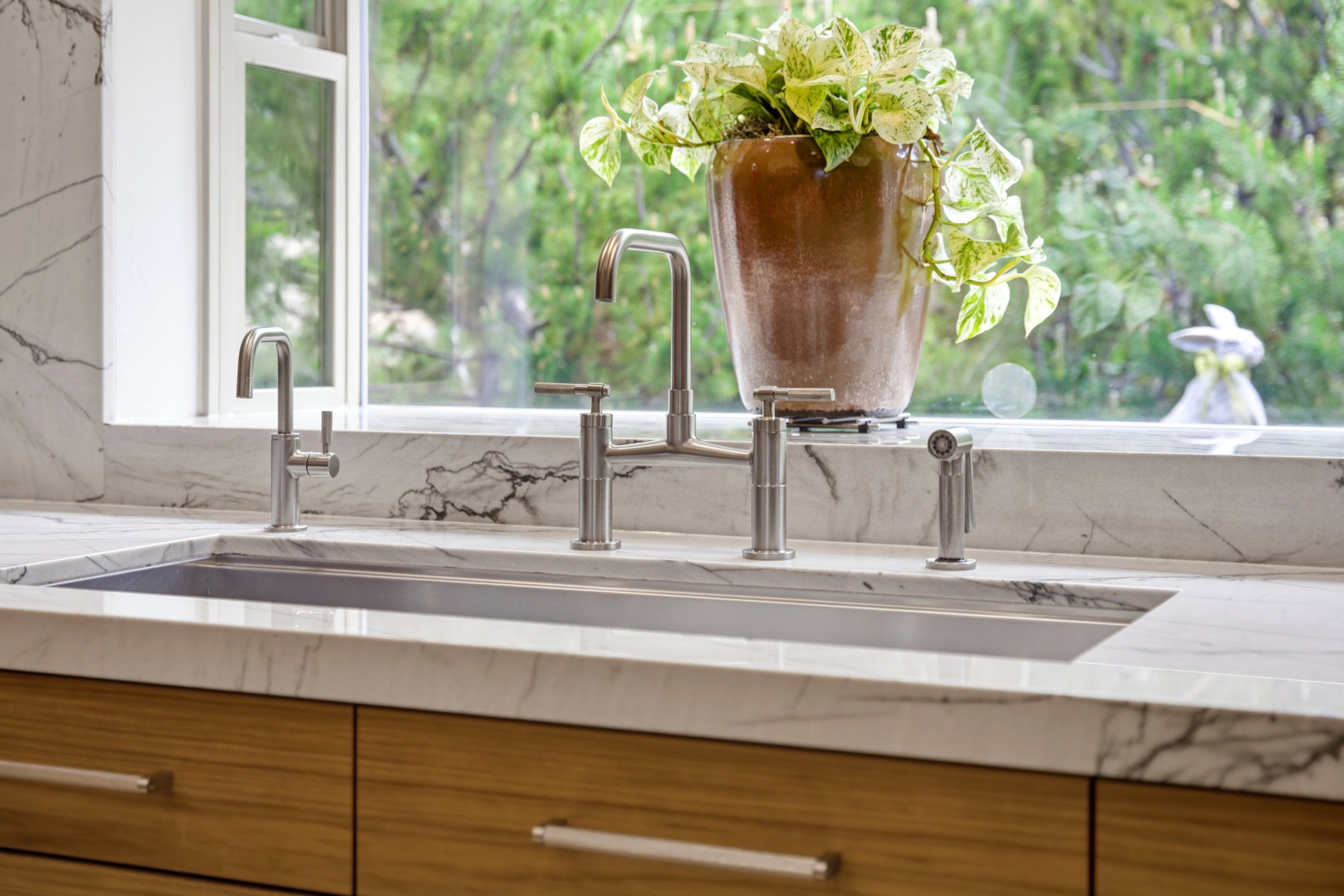 Dual basin stainless steel sink with two contemporary brushed nickel faucets