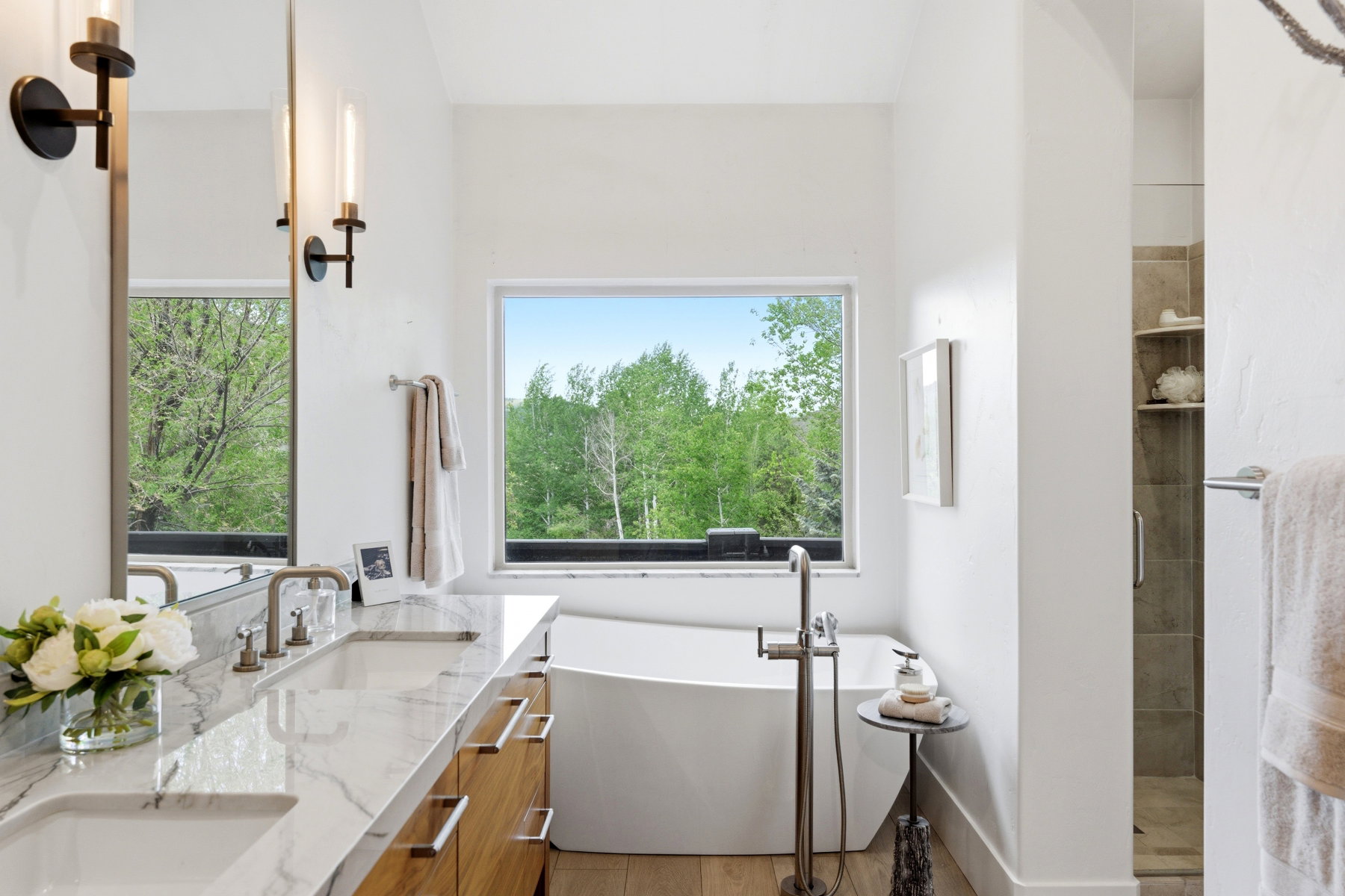 Bathroom featuring a freestanding soaking tub, dual vanity with undermount sinks, and a walk-in shower with built-in shelving