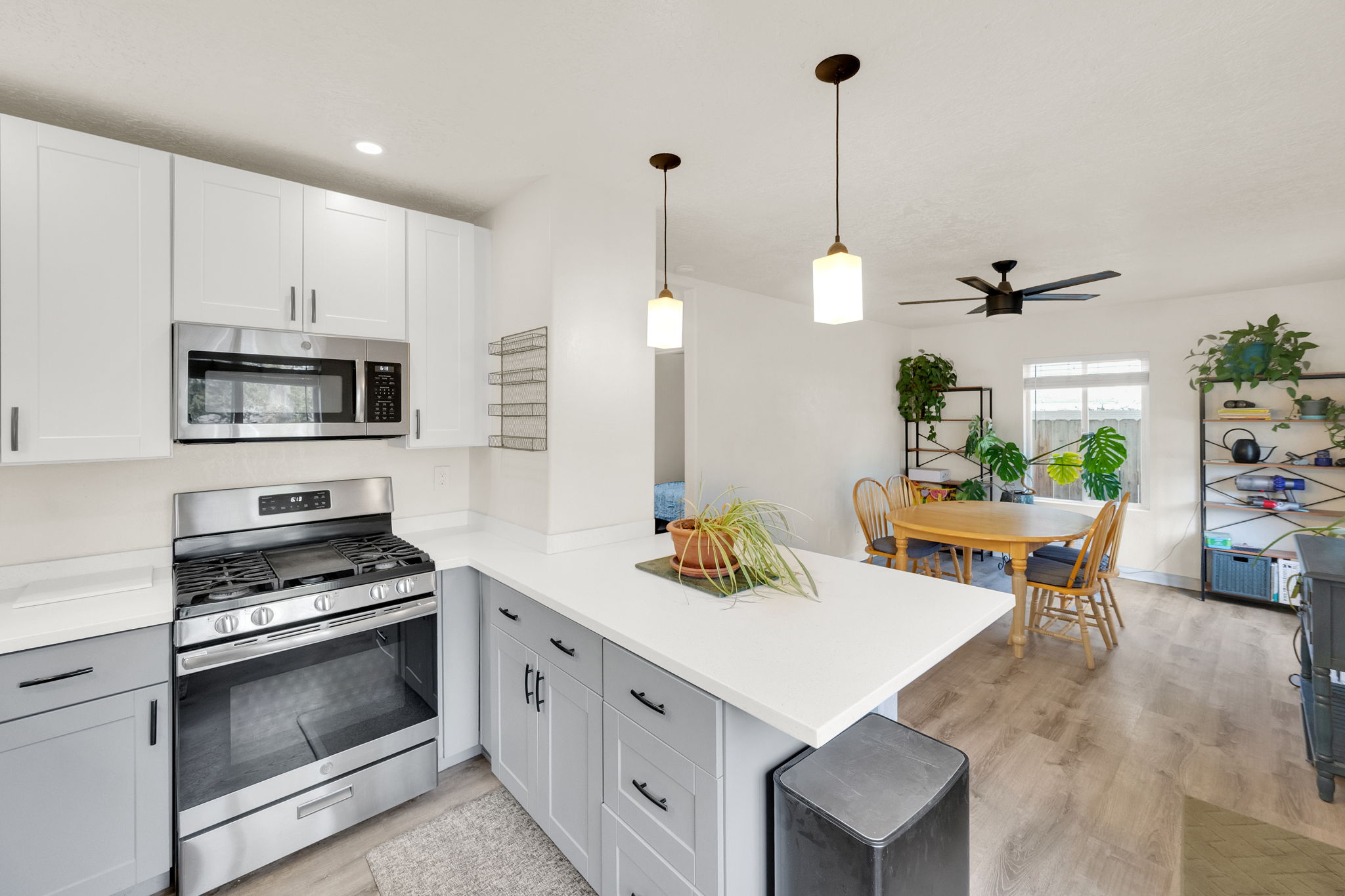 Open-concept kitchen featuring two-tone cabinetry, stainless steel appliances, and a peninsula with countertop seating