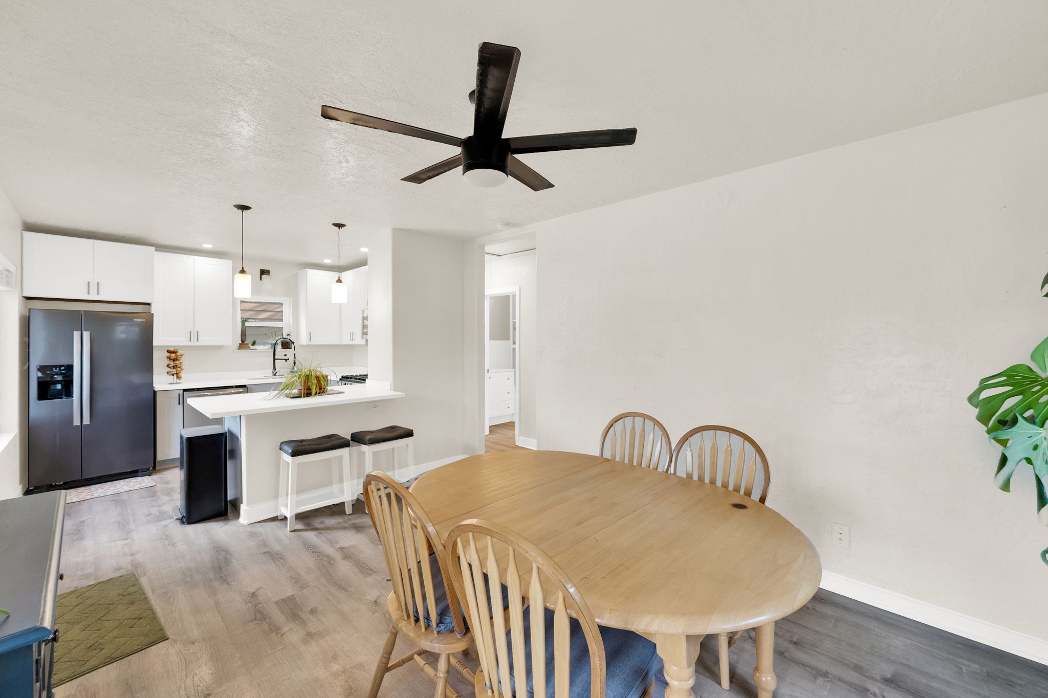 Open-concept living space featuring wood-finish flooring, a contemporary ceiling fan, and recessed lighting