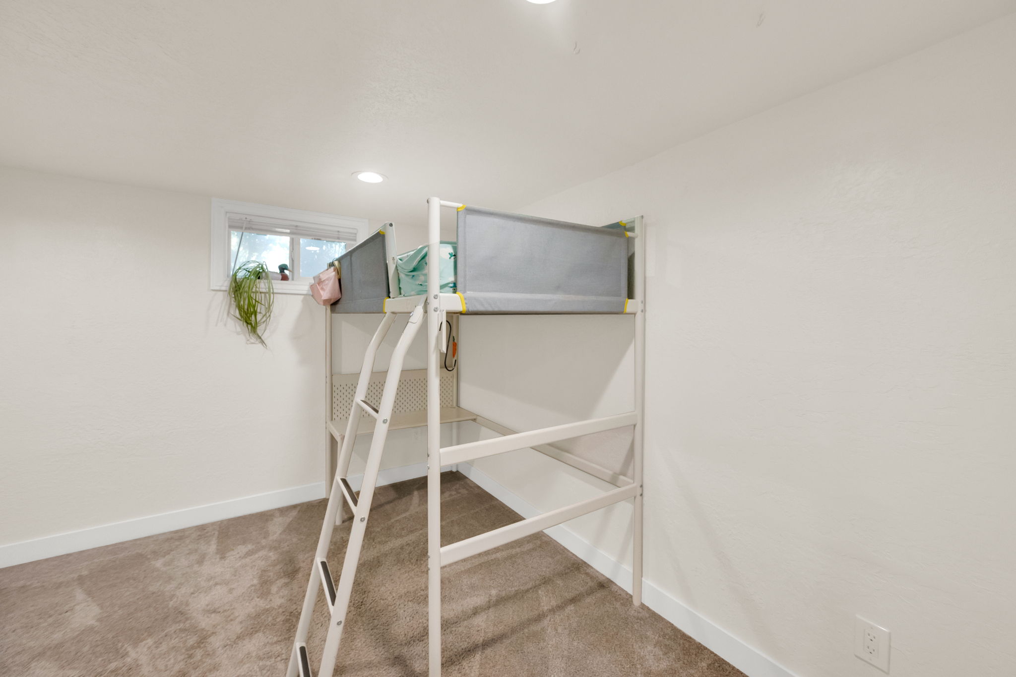 Carpeted room with recessed lighting and a window featuring white trim