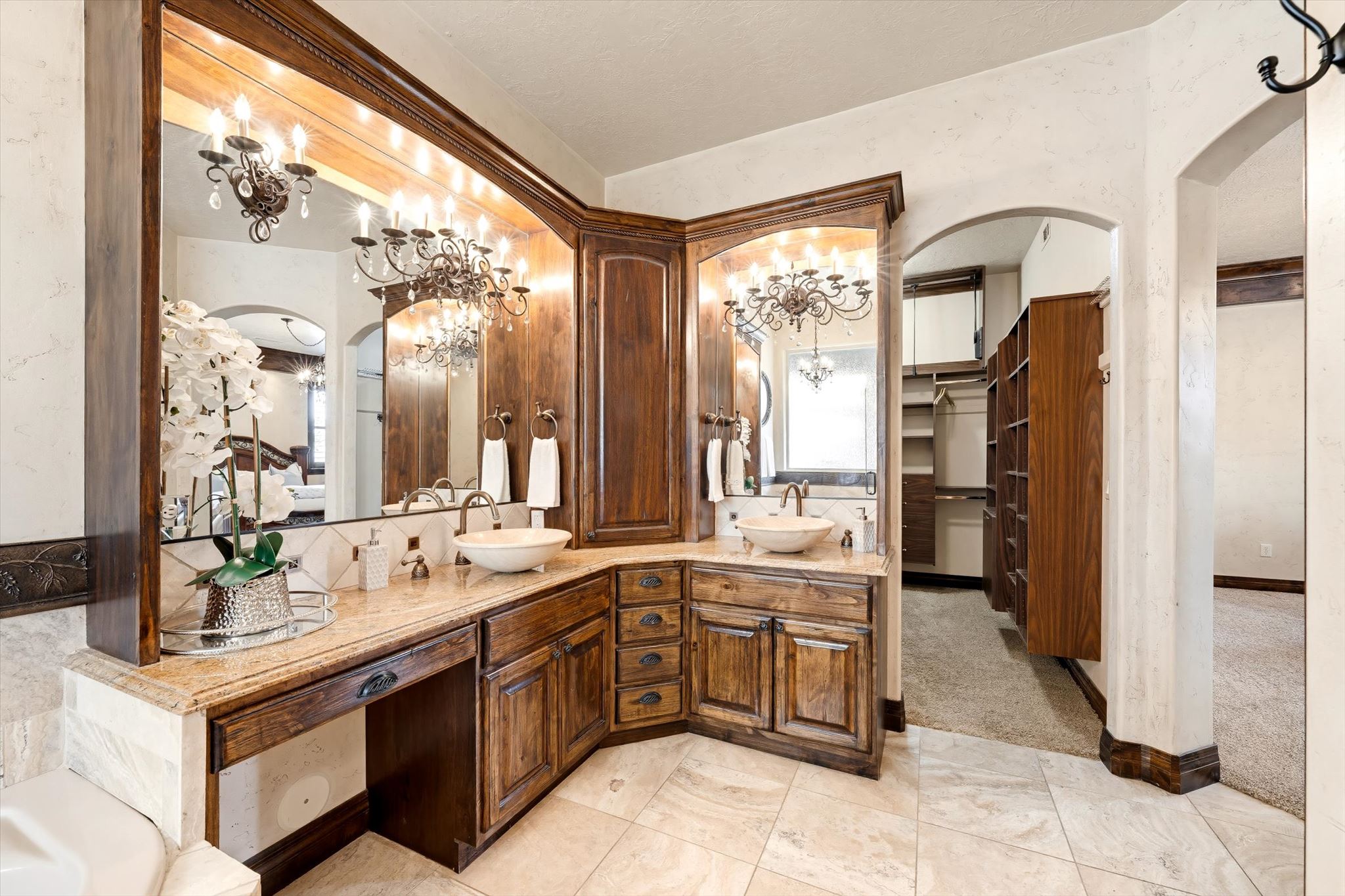Custom wood cabinetry vanity featuring dual vessel sinks and sconce lighting