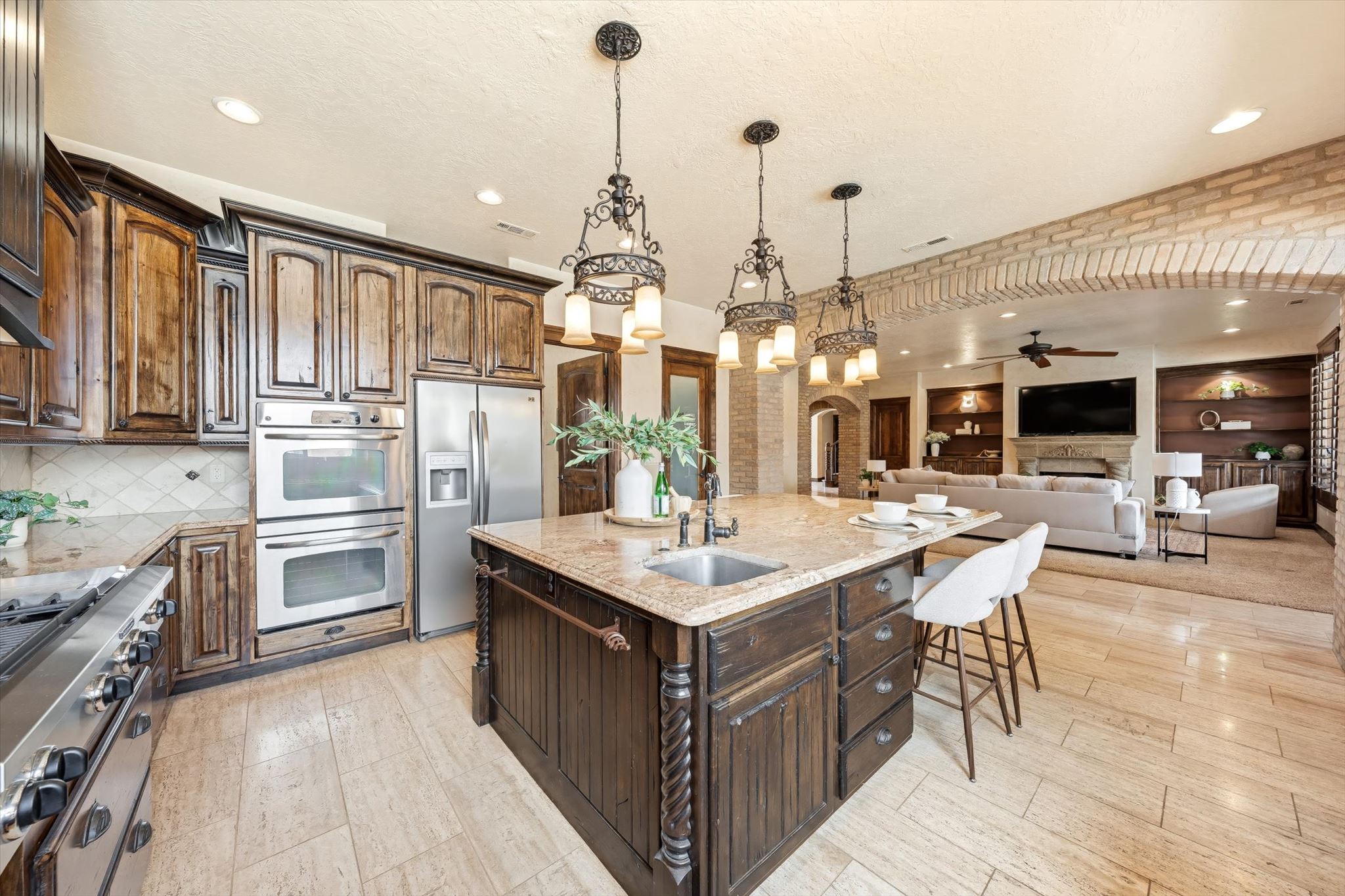 Gourmet kitchen featuring a large island with sink, stainless steel appliances, and wood-finish cabinetry