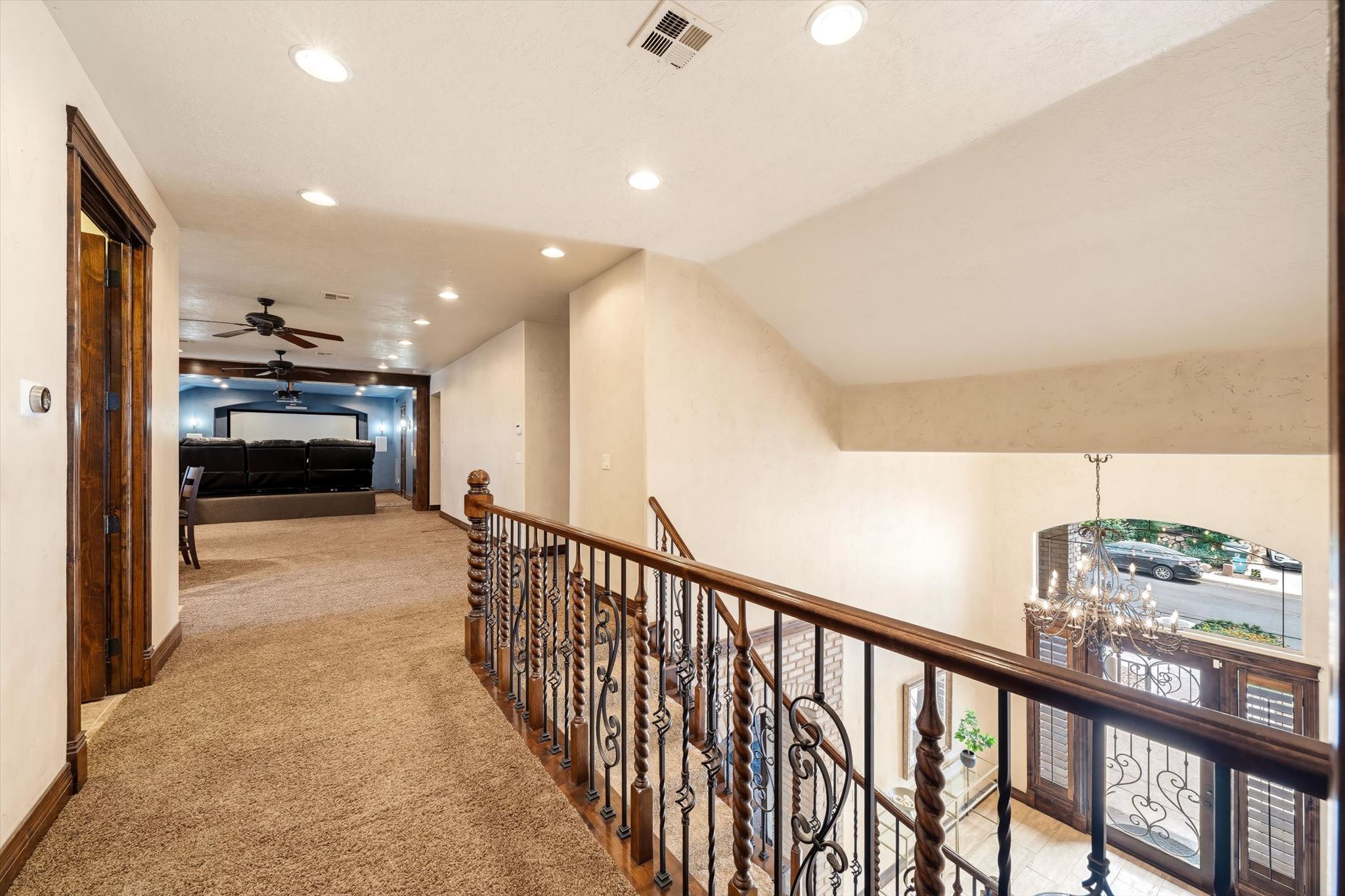 Upper-level hallway with carpeted flooring and recessed lighting