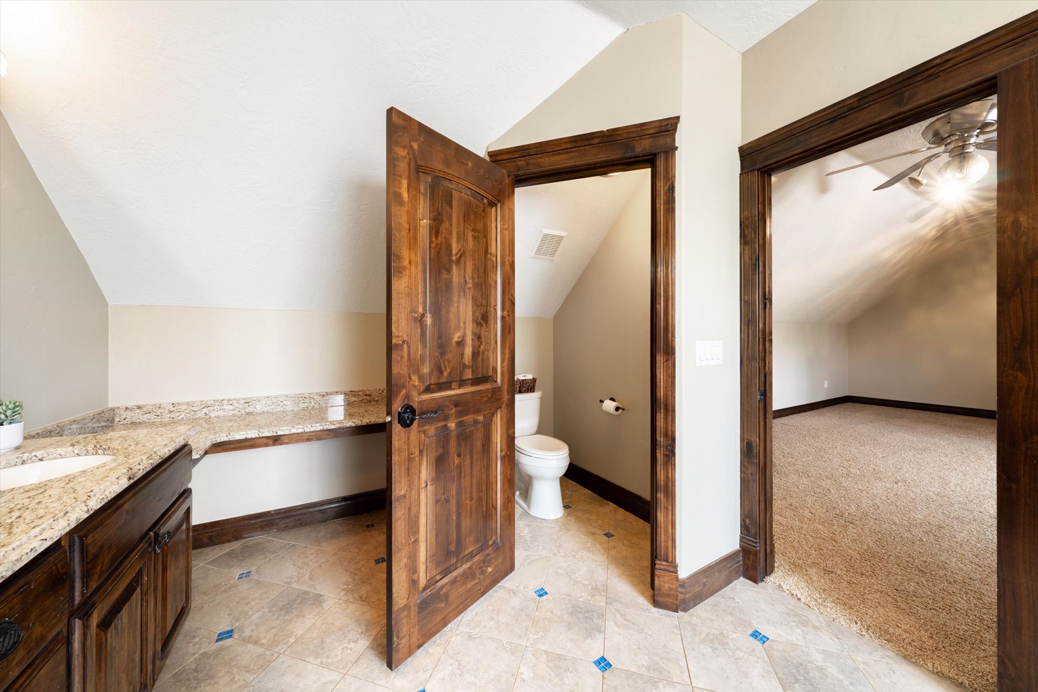 Bathroom vanity featuring a granite countertop, undermount sink, and dark wood cabinetry