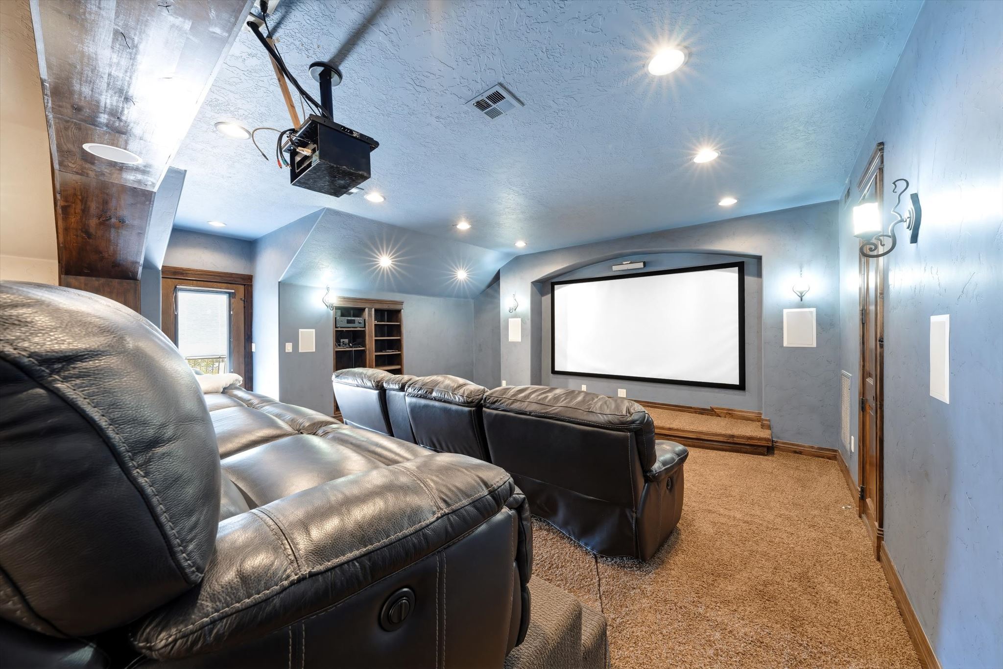 Dedicated media room featuring a large projection screen and elevated seating