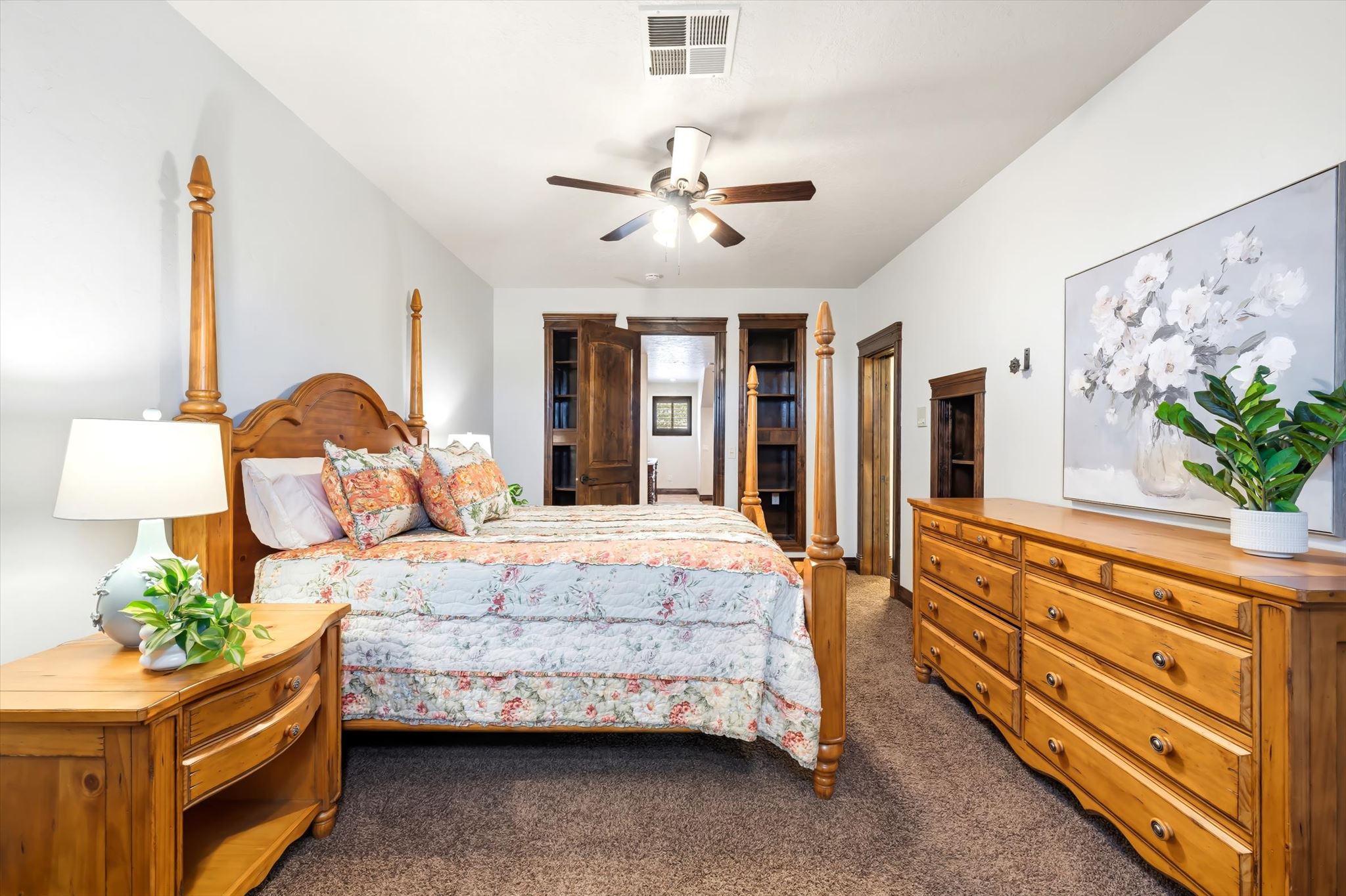 Spacious bedroom featuring light-colored walls and dark brown carpet flooring