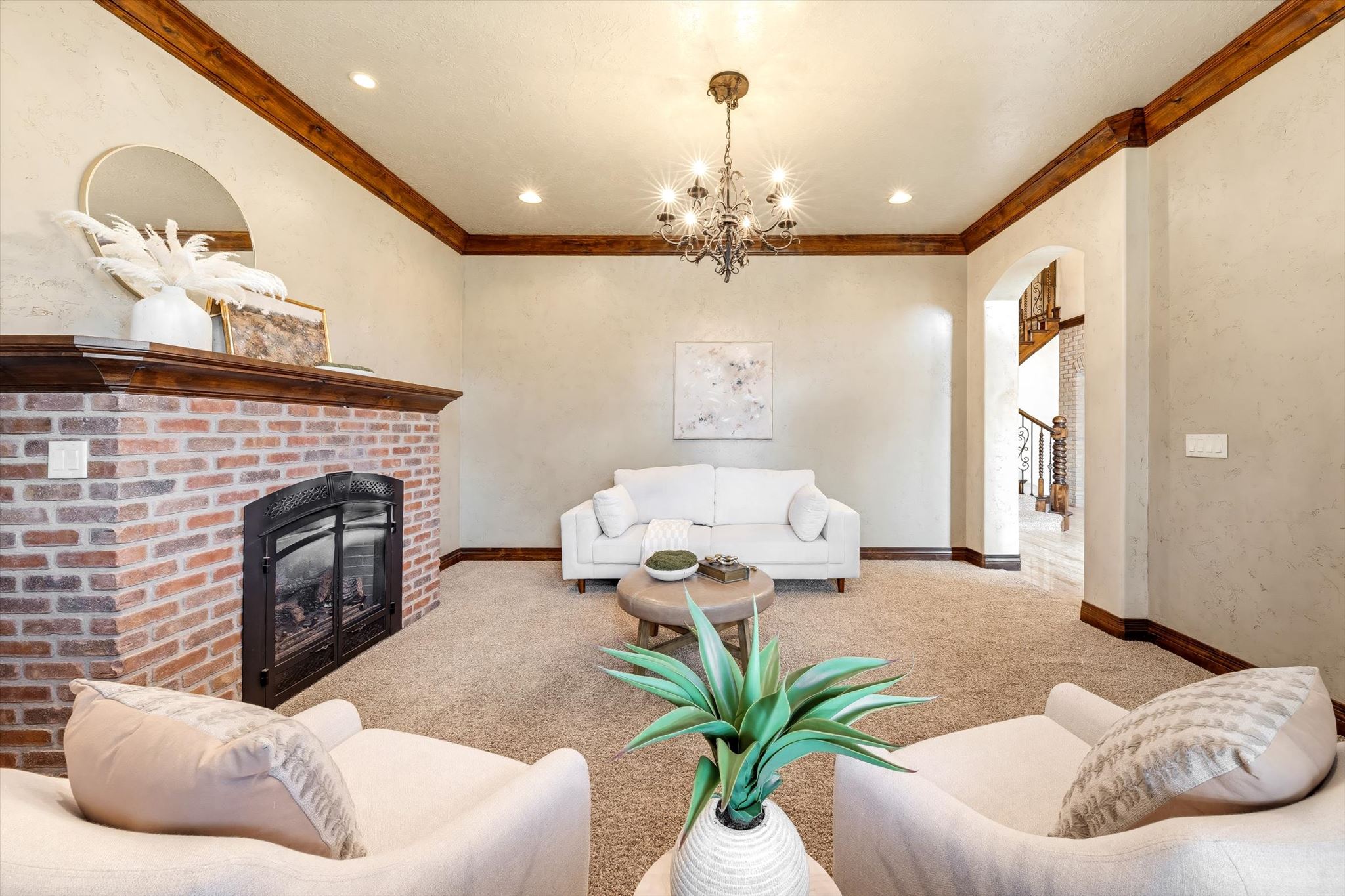 Living area featuring a brick fireplace with a wood mantle, recessed lighting, and a decorative chandelier