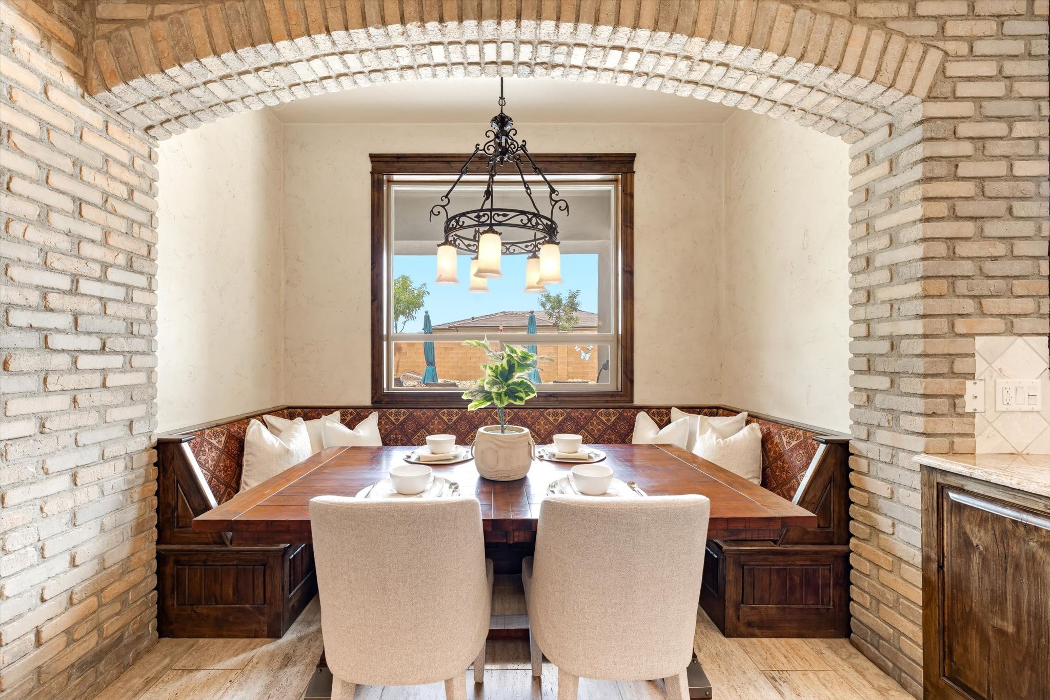 Brick archway framing a built-in dining nook with dark wood-finish benches