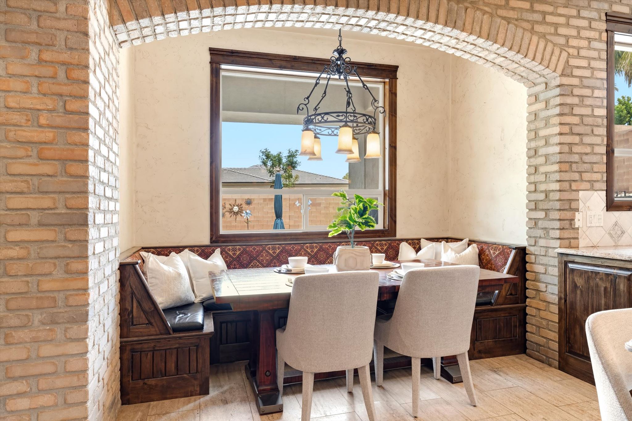 Dining nook featuring a built-in bench with storage, a dark wood table, and two upholstered chairs