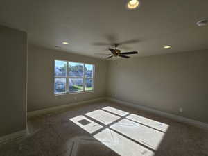 Spacious room with a large multi-pane window, recessed lighting, and a ceiling fan