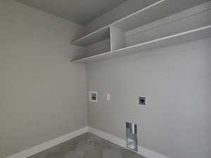 Utility room featuring built-in shelving, tile flooring, and appliance hookups