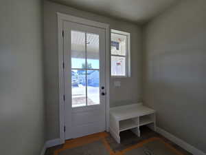 Entryway featuring a glass-paned door, a white storage bench, and wood-finish flooring