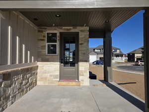 Covered porch entry featuring stone veneer and vertical siding accents