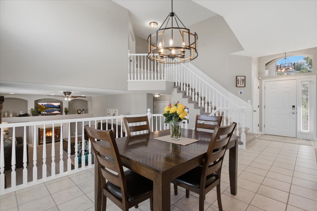 Entryway featuring a double door with an arched transom, a wrought iron chandelier, and a staircase with white balusters