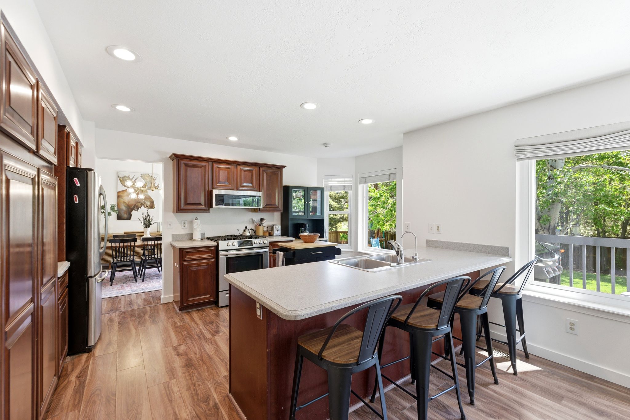 Spacious kitchen featuring LVP flooring, recessed lighting, and a large center island with integrated sink