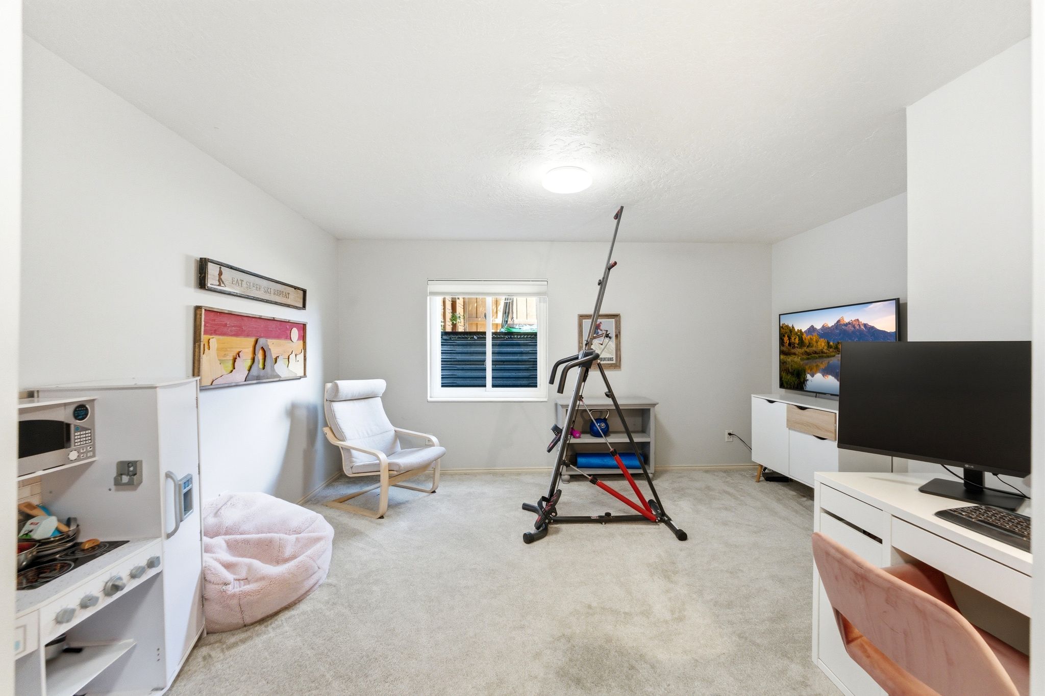 Carpeted room with a recessed window, light-colored walls, and a ceiling-mounted light fixture
