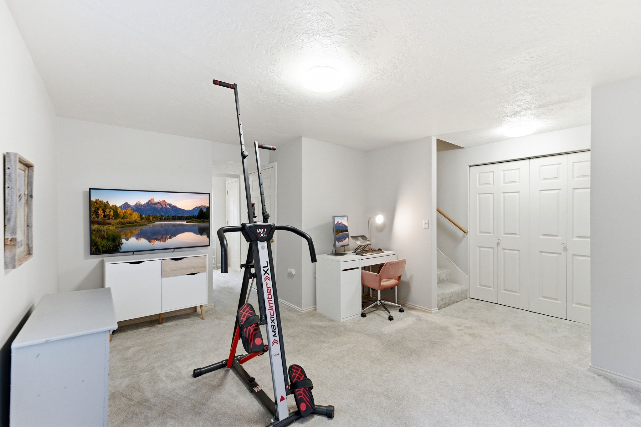 Spacious room featuring light-toned carpeting, recessed lighting, and bright white walls