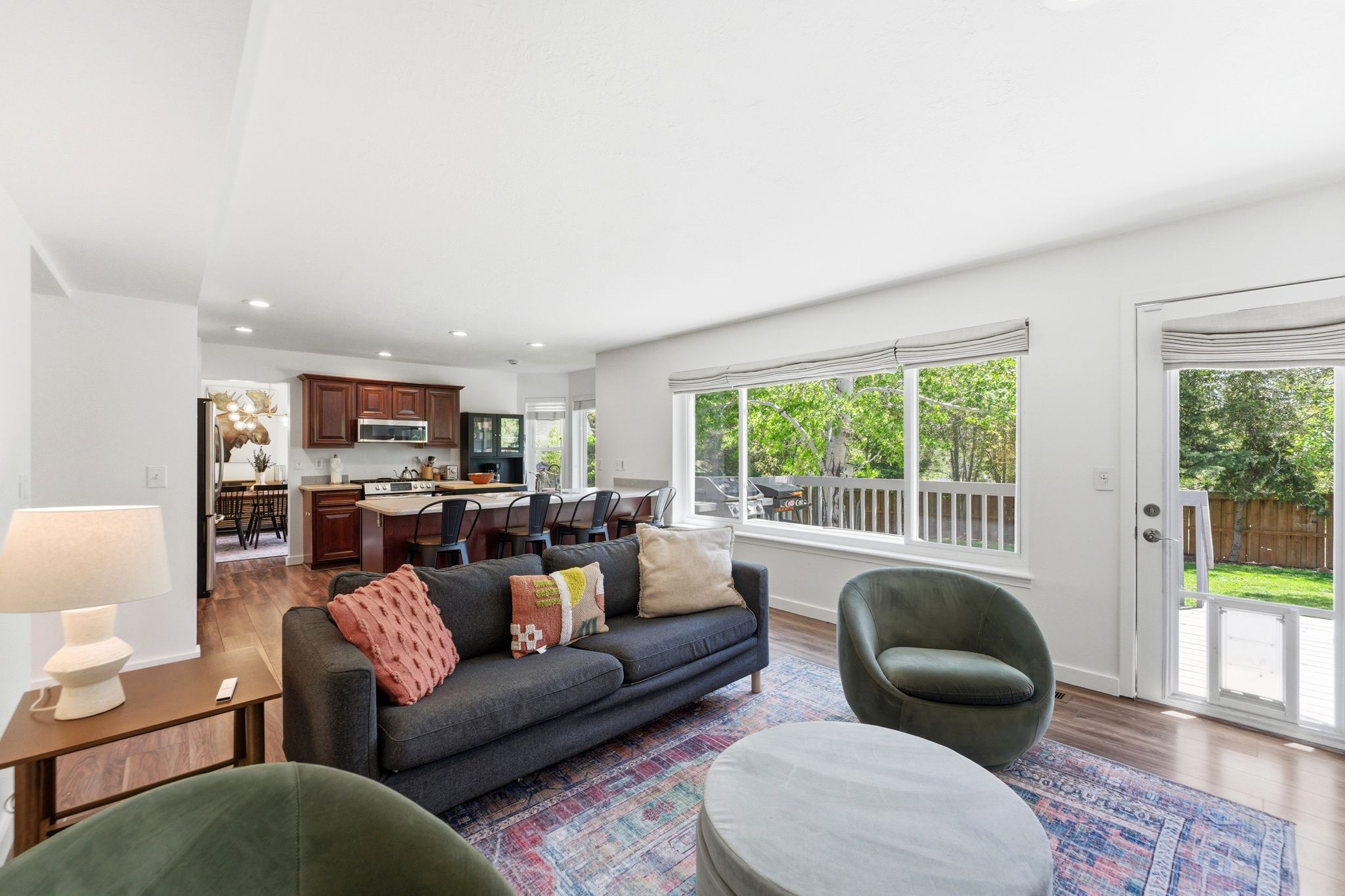 Open-concept living area featuring LVP flooring, recessed lighting, and expansive windows