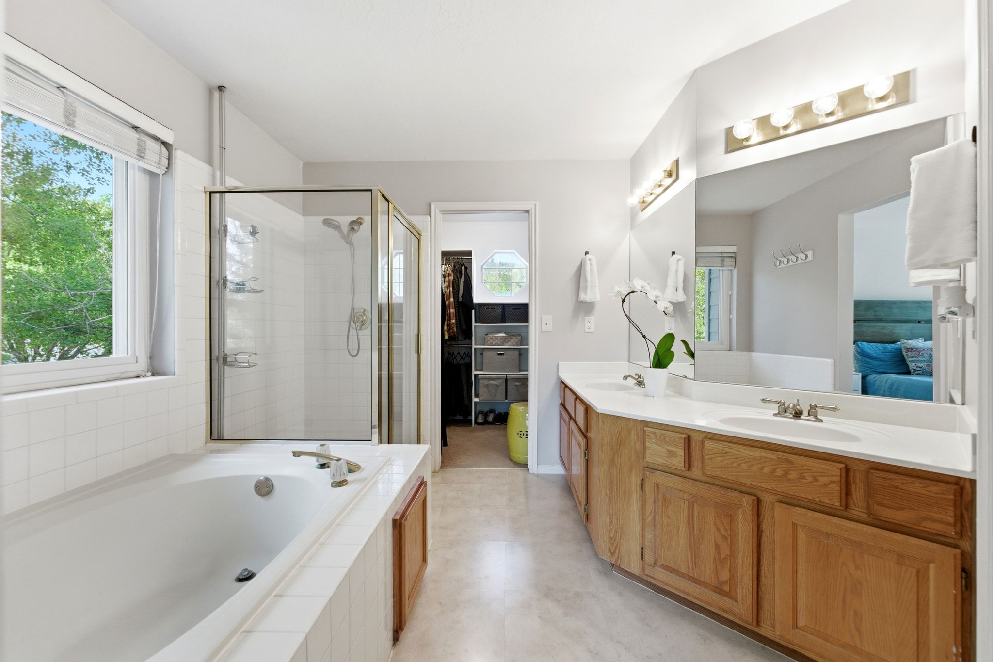 Primary Bath with Dual vanity with light wood cabinetry, white countertops, and undermount sinks