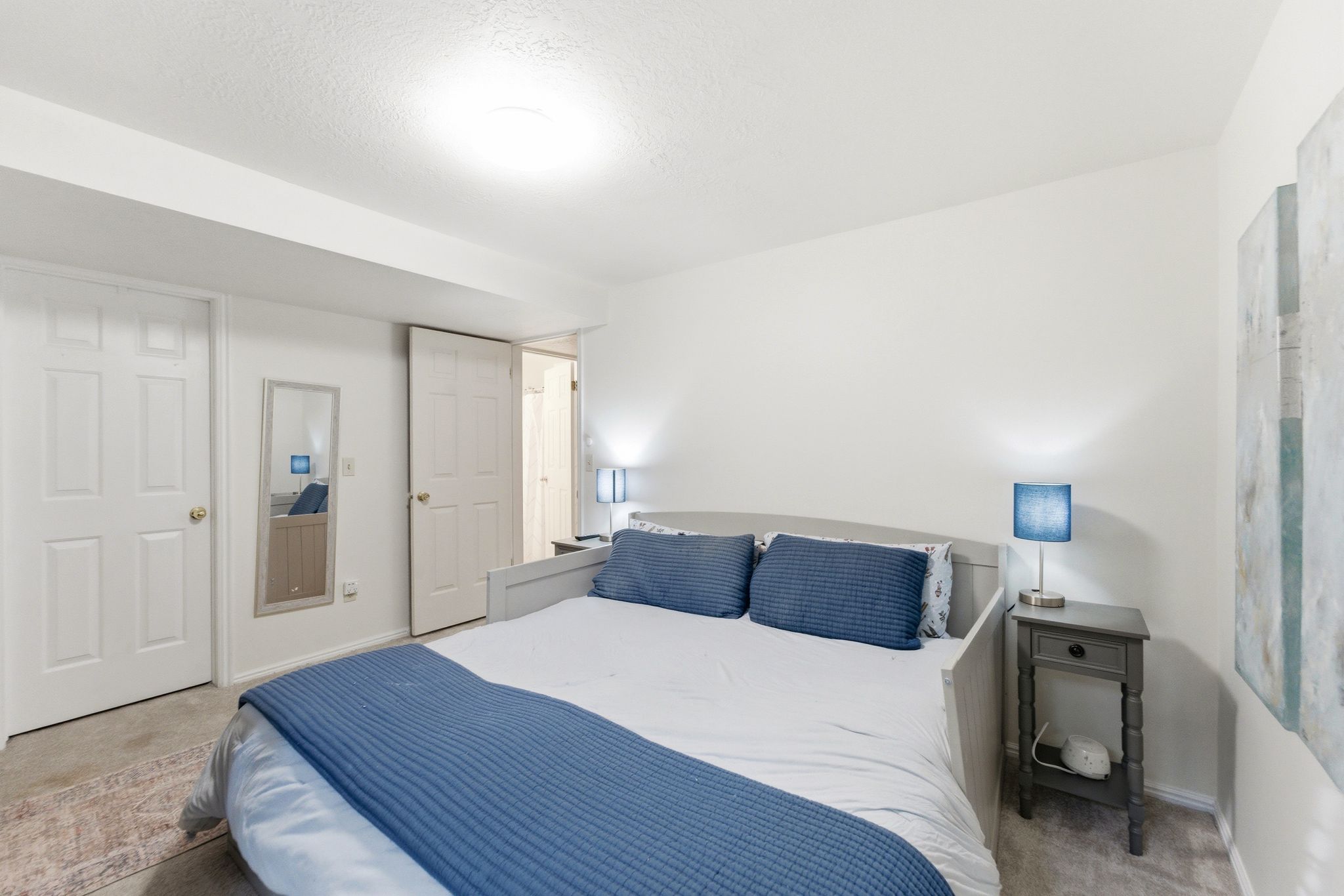 Bedroom featuring neutral wall paint, carpet flooring, a ceiling-mounted light fixture, and two panel doors