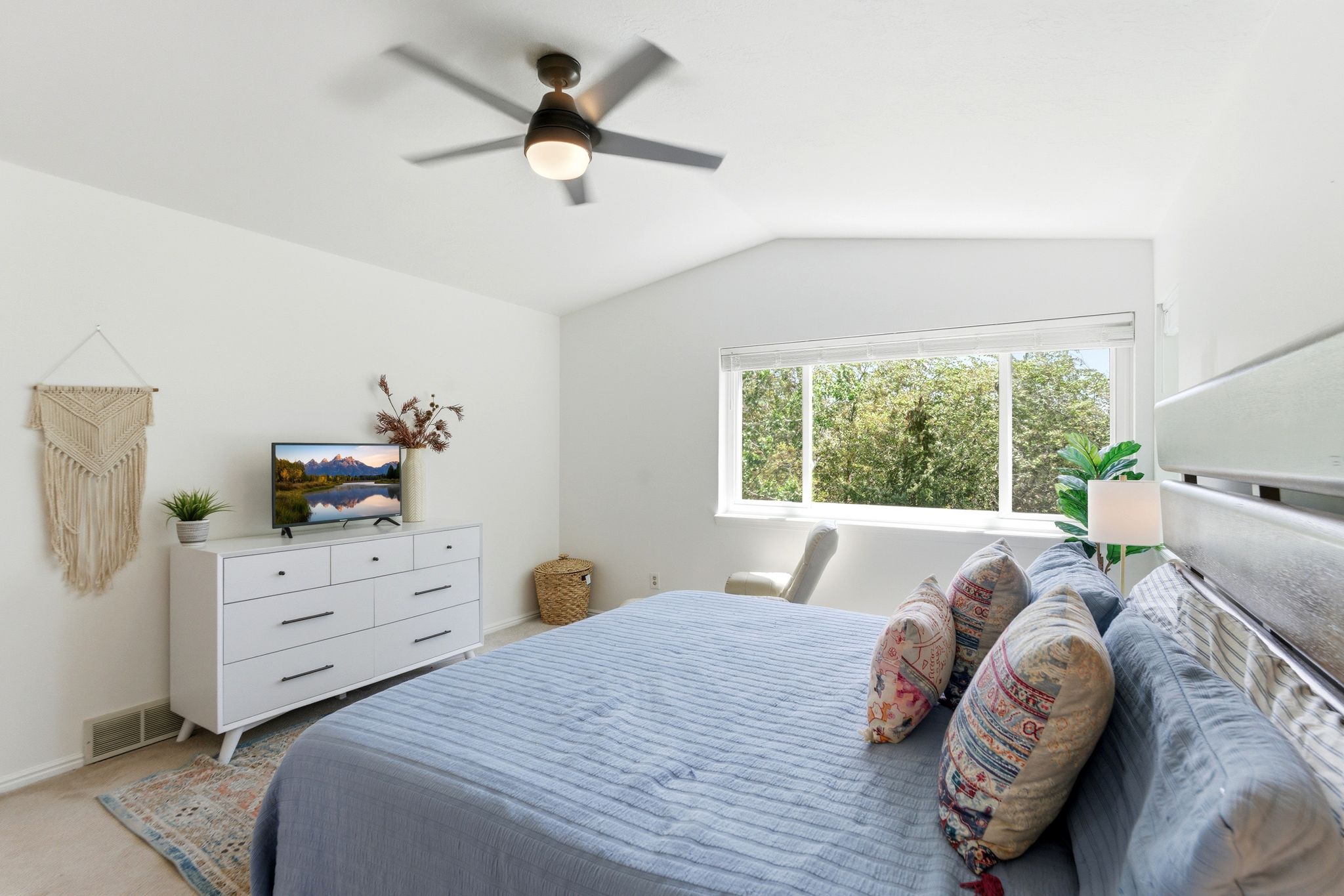 Upper Primary Bedroom featuring Vaulted ceilings enhance this bright room, featuring an expansive window offering exterior tree views